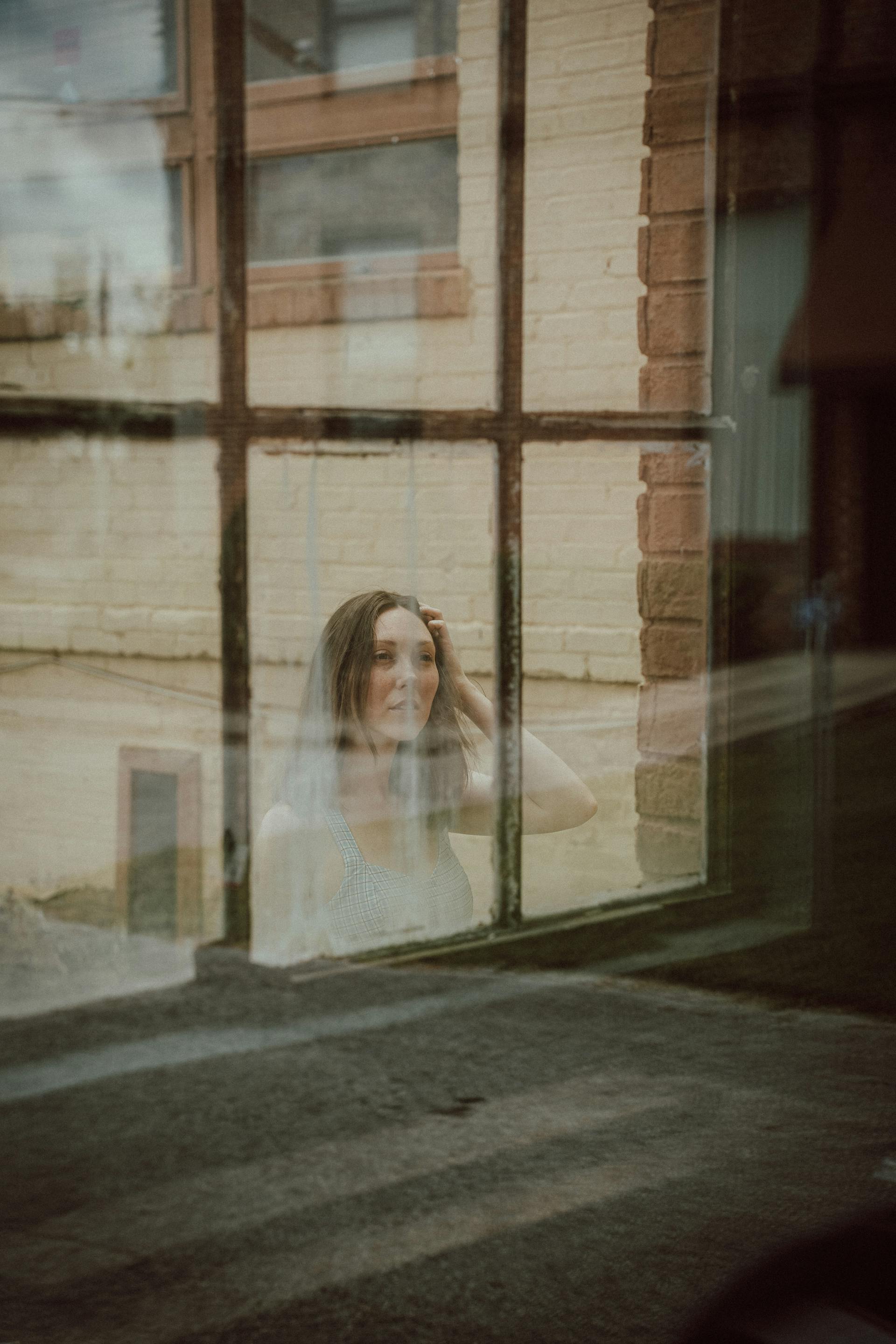 A woman looking through the window of a building | Source: Pexels