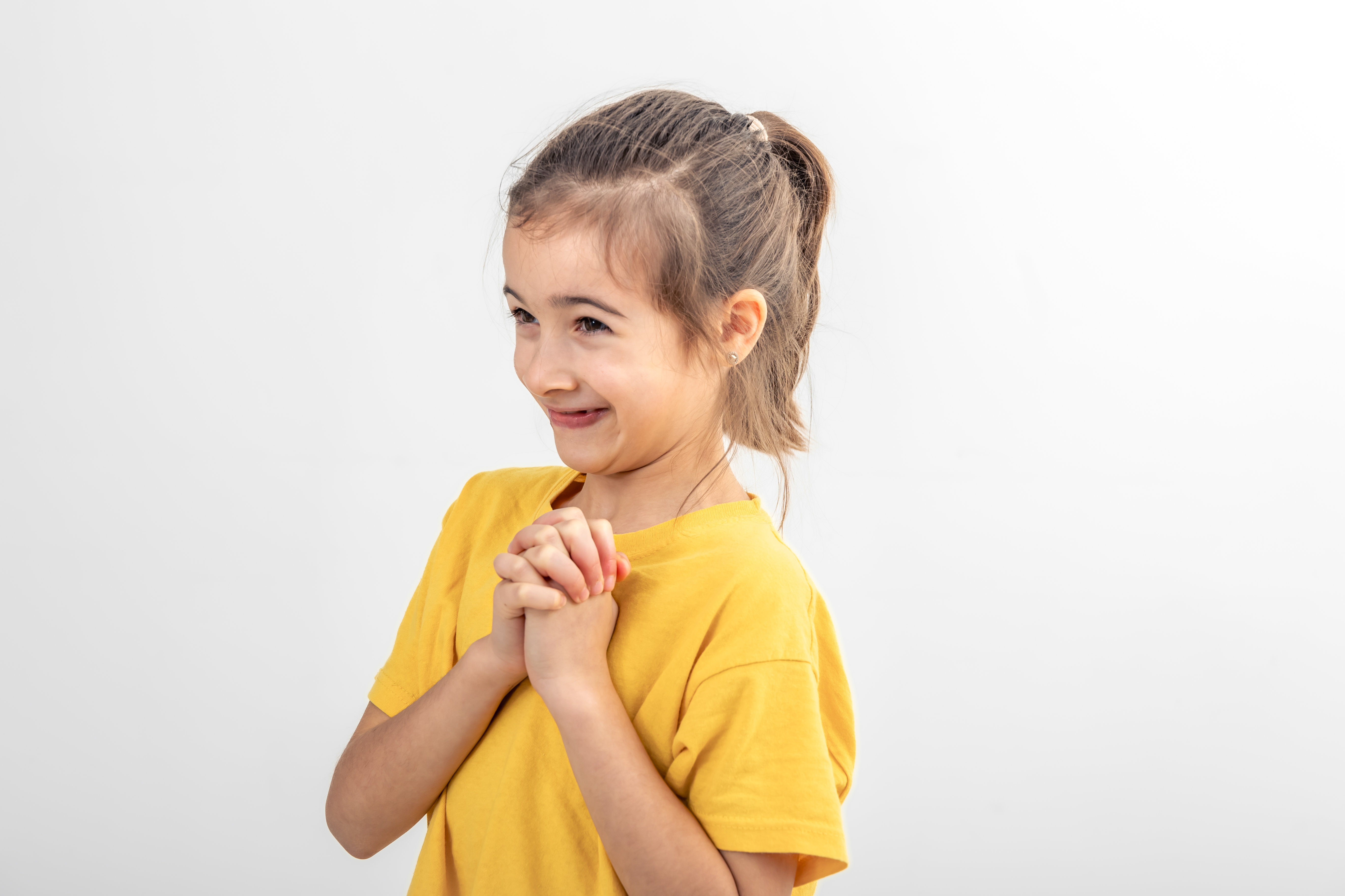 A happy girl clutching her hands | Source: Freepik