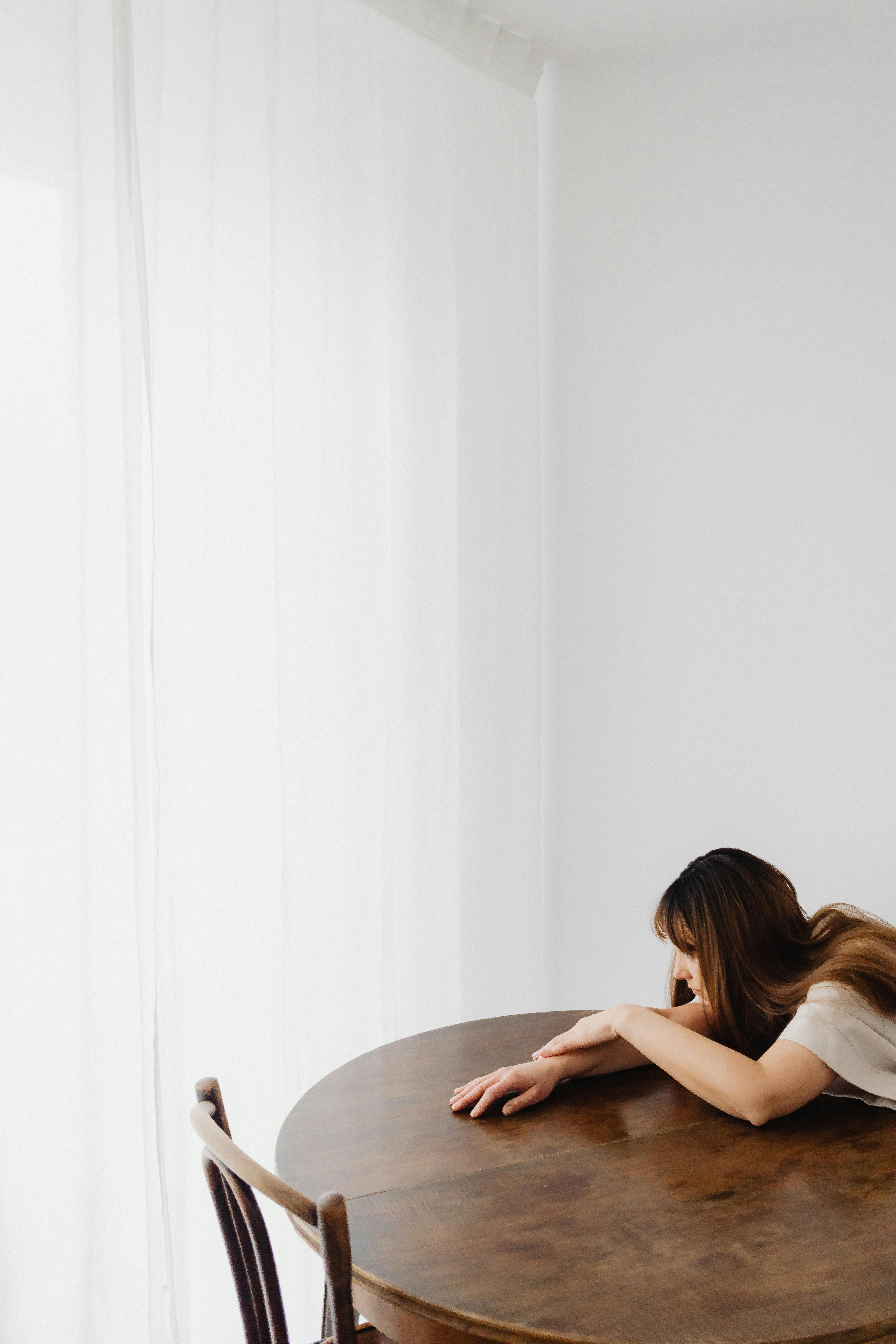 A woman leaning on a table | Source: Pexels