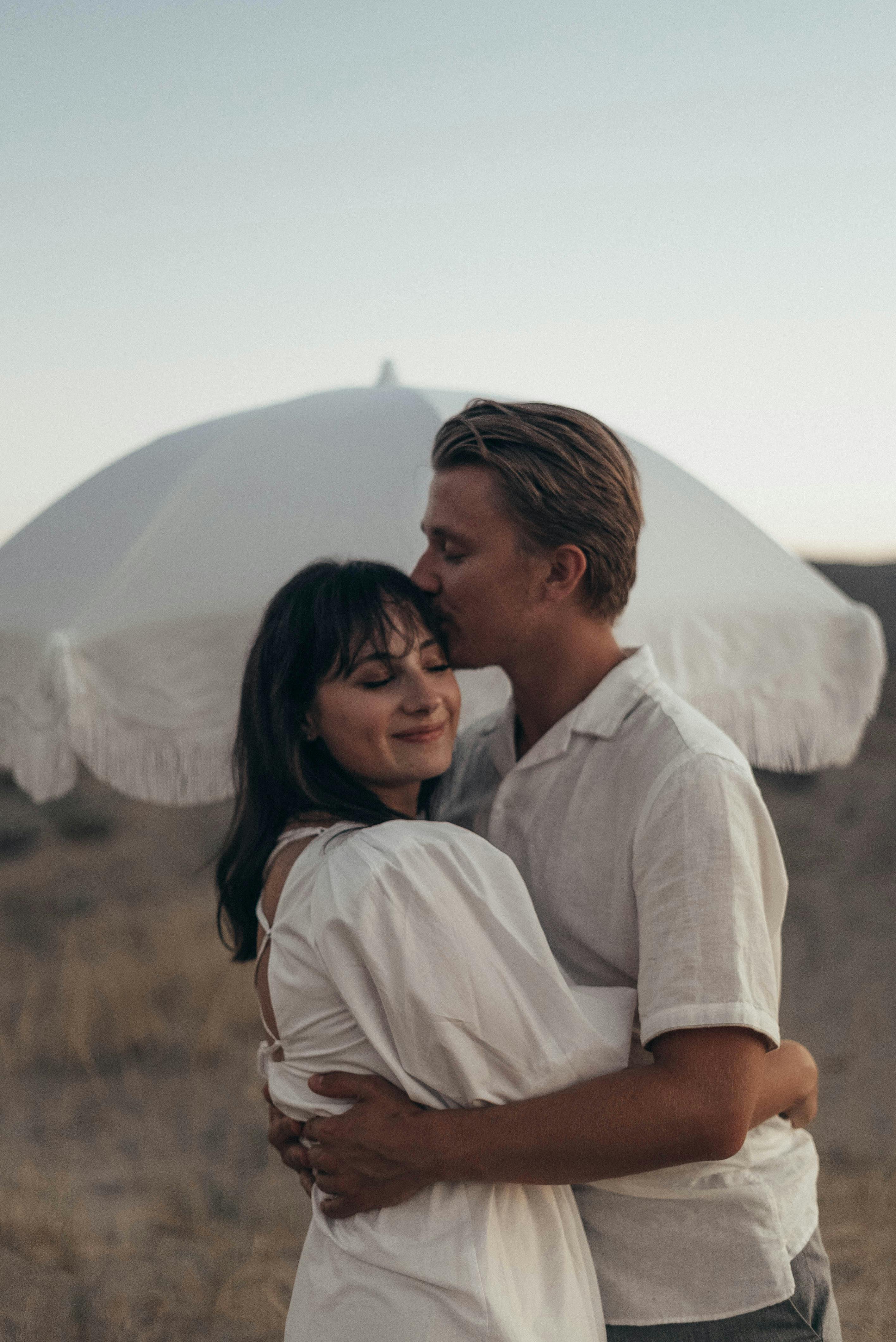 A man kissing a woman's forehead | Source: Pexels