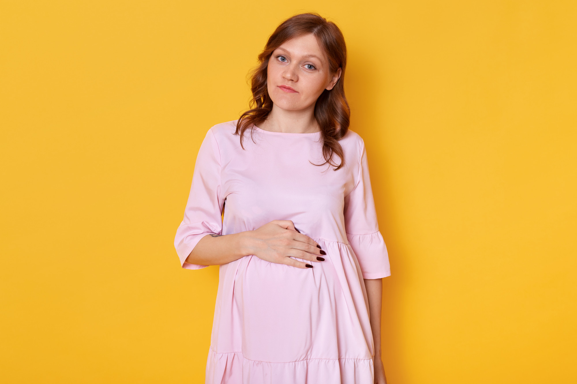A pregnant woman holding her baby bump | Source: Freepik