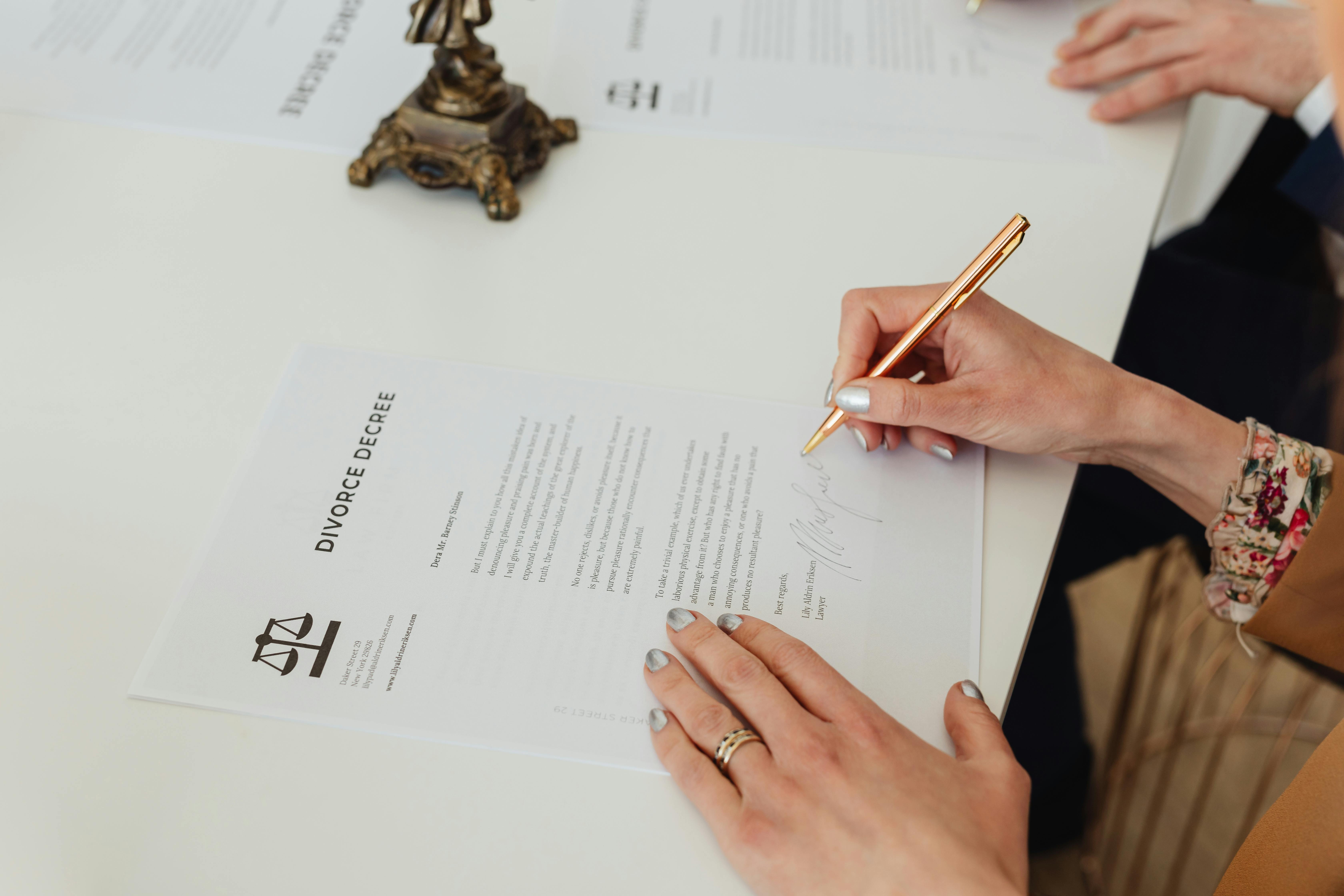 Divorce paperwork being signed | Source: Pexels