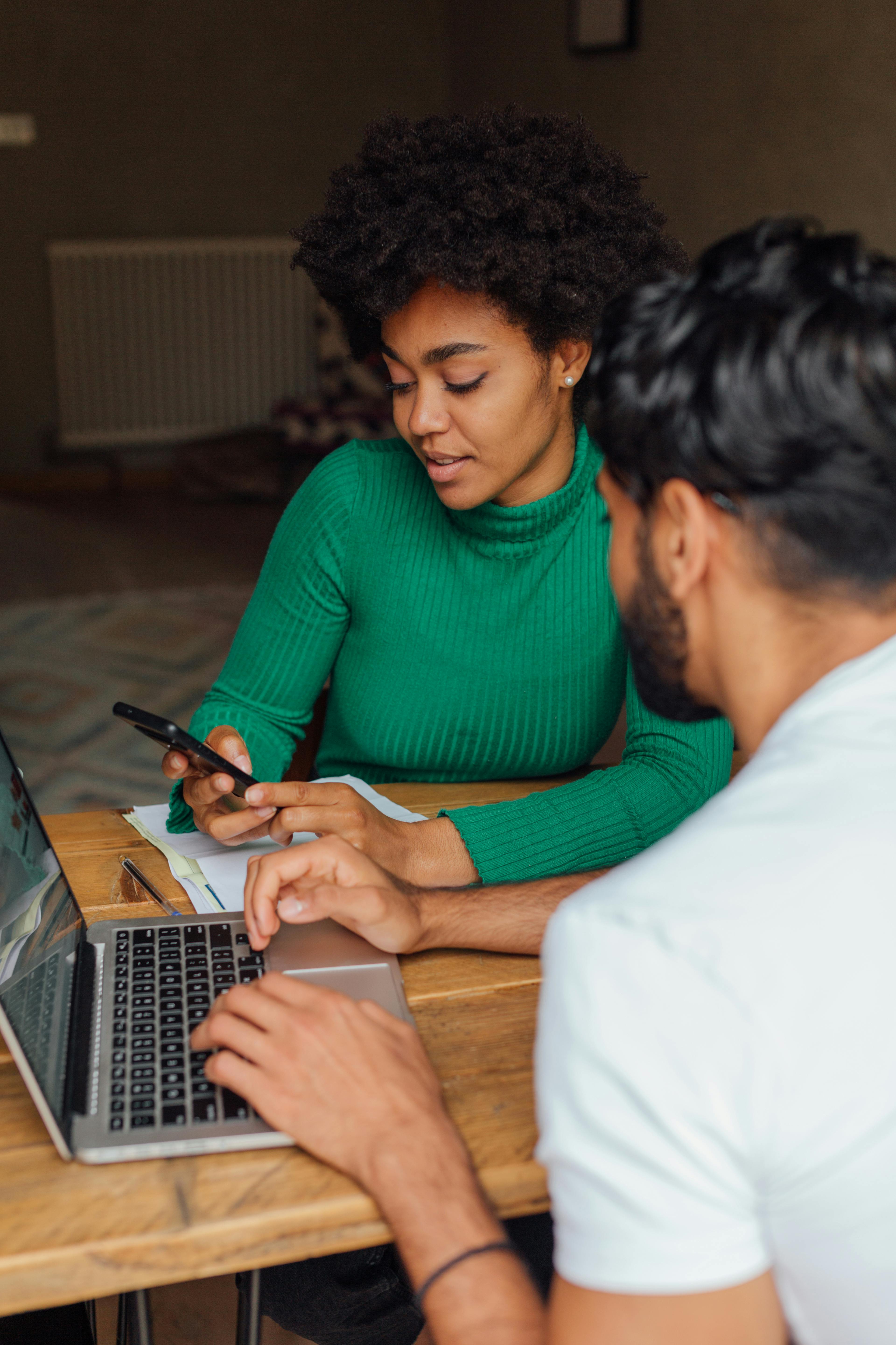 A man and a woman talking while working together | Source: Pexels