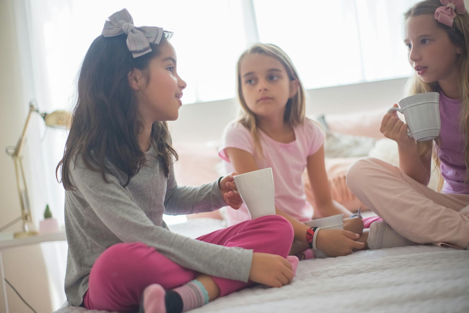 Three girls holding cups while talking | Source: Pexels