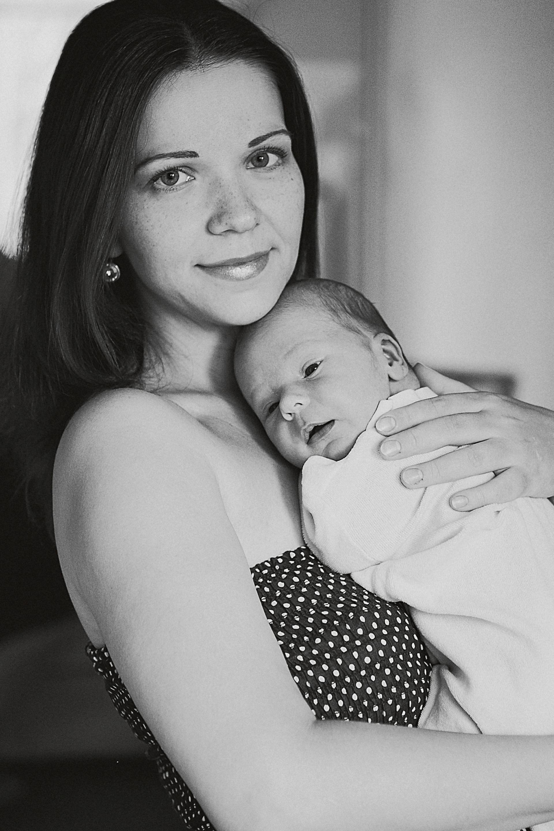 A smiling woman holding a baby | Source: Pexels