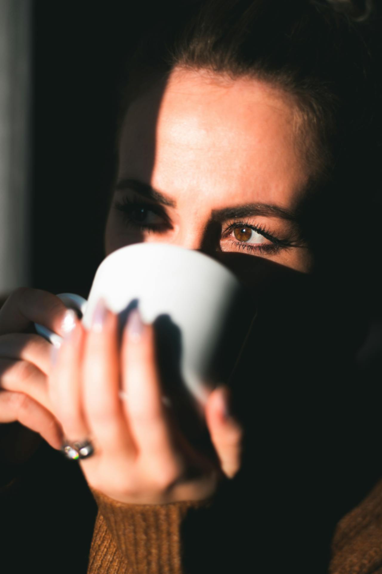 A woman drinking a beverage from a white ceramic cup | Source: Pexels