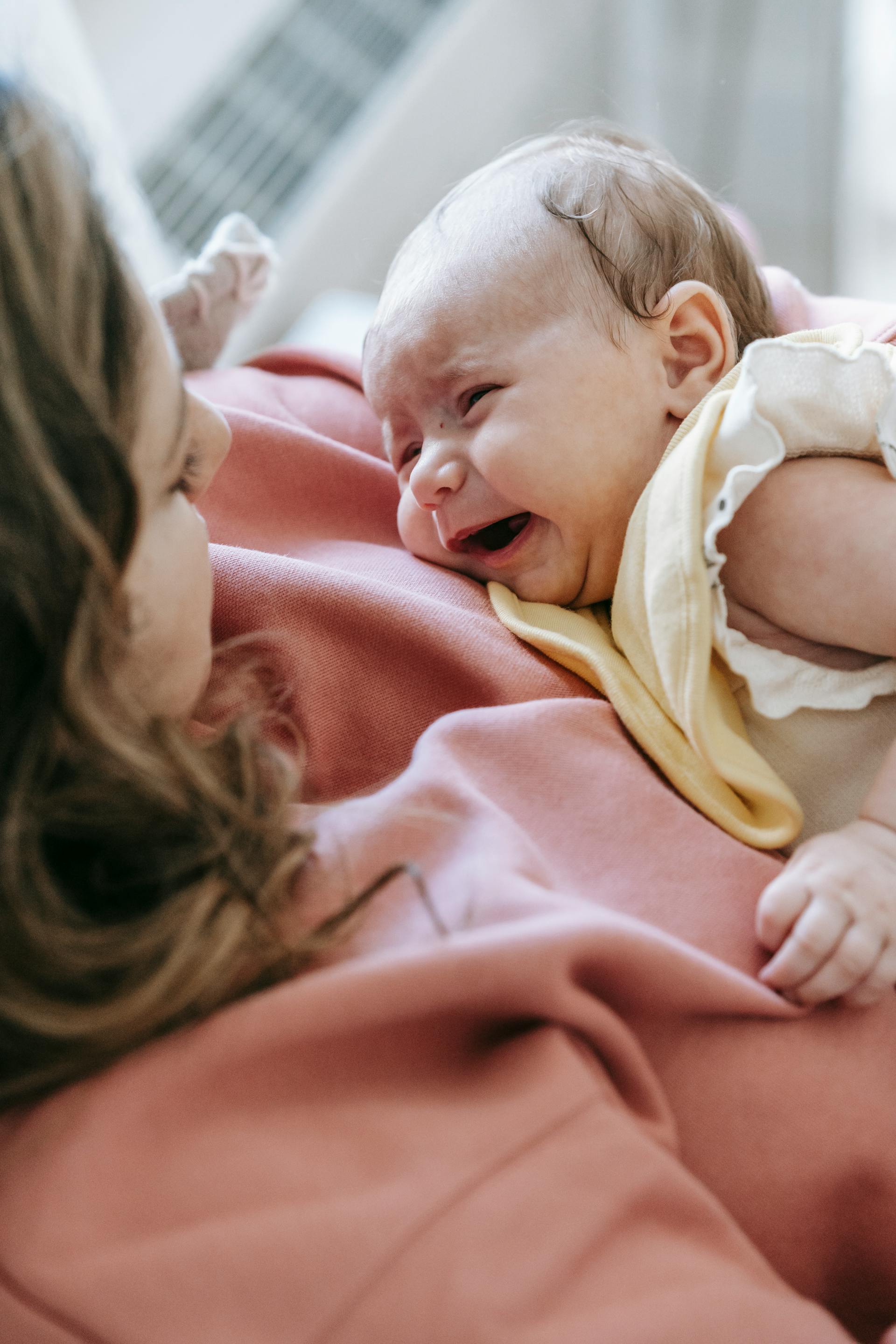 A woman holding a crying baby | Source: Pexels
