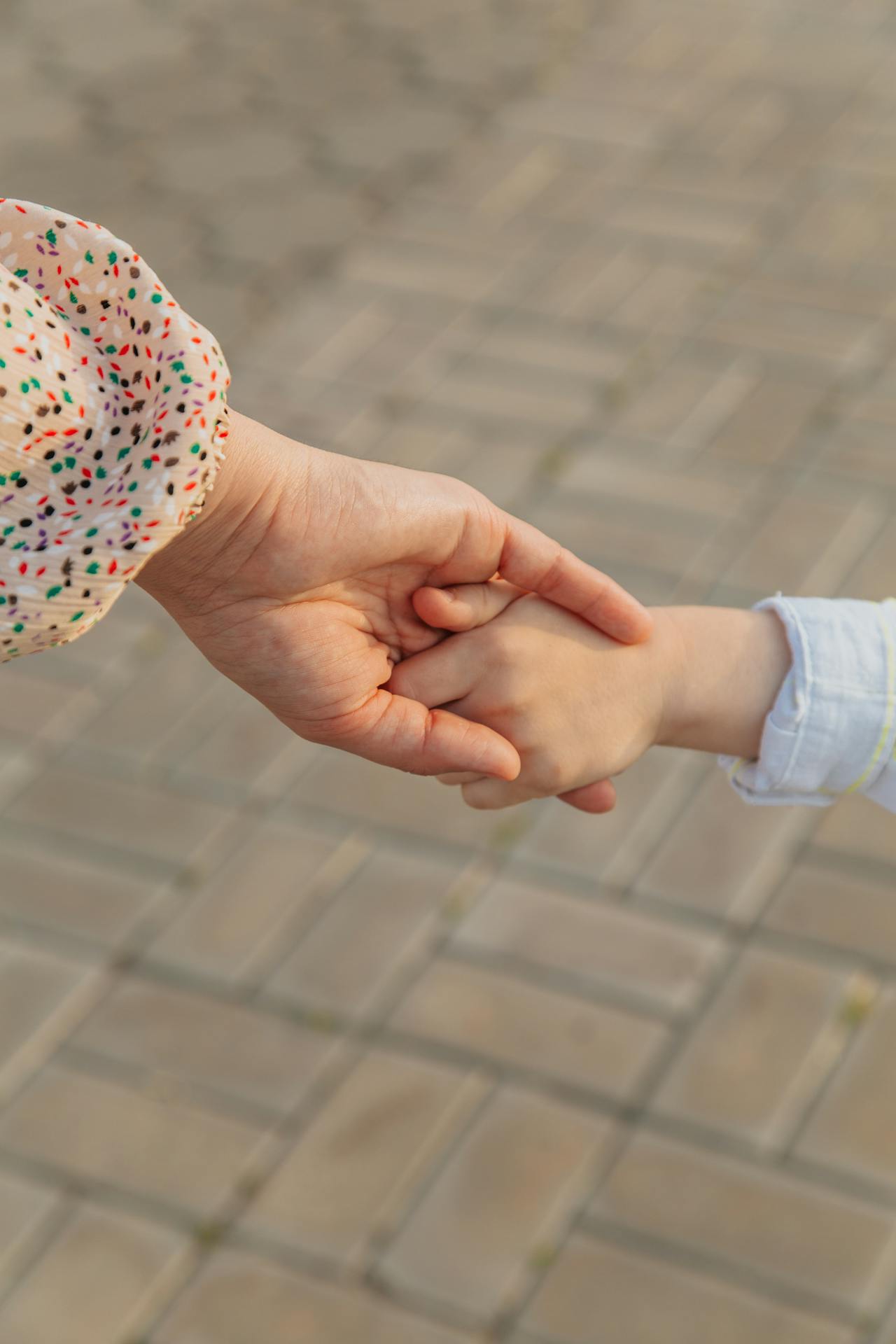 Foto recortada de uma mãe segurando a mão do filho pequeno | Fonte: Pexels