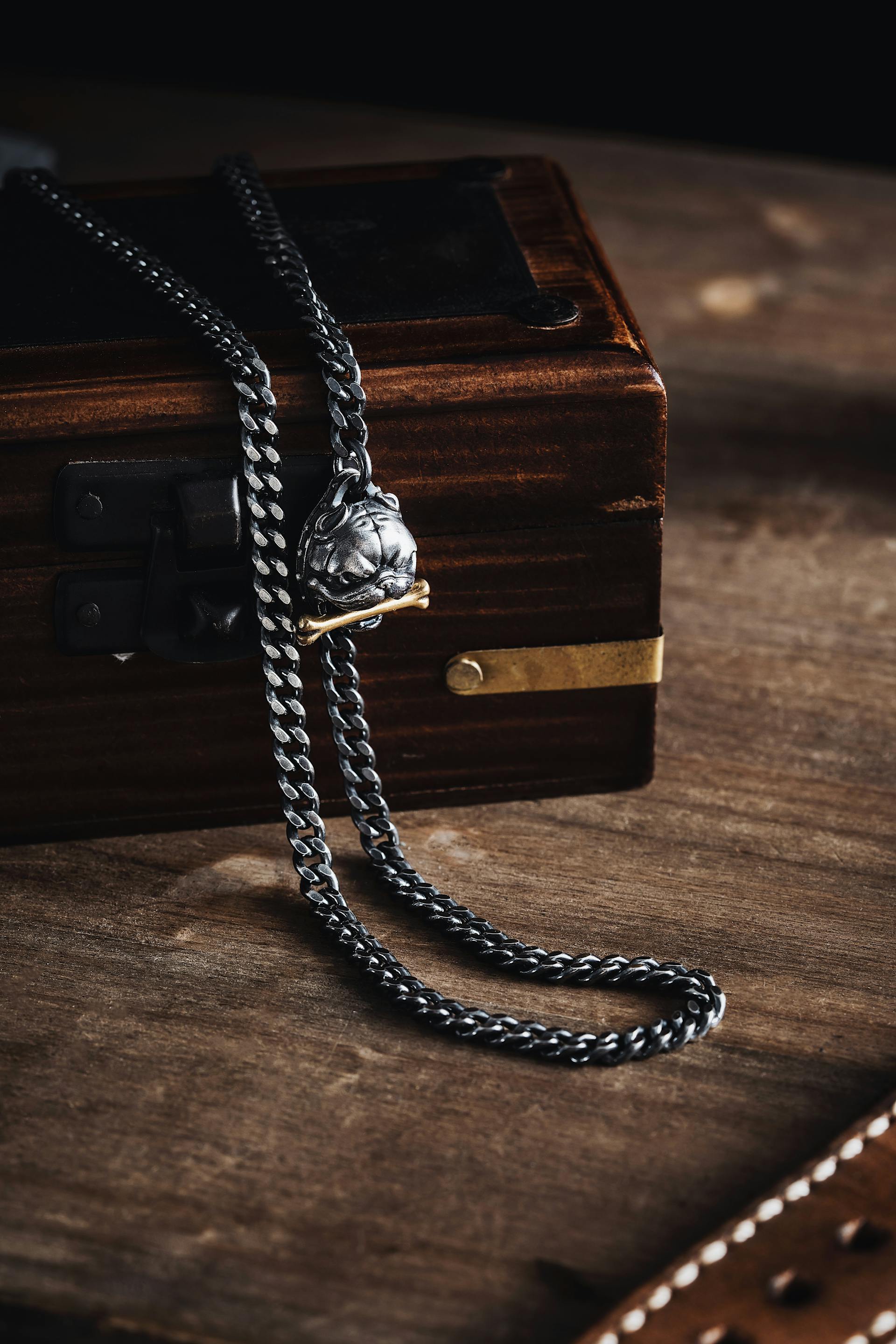 A close-up of a Cuban link chain with a dog clasp lying on top of a box | Source: Pexels