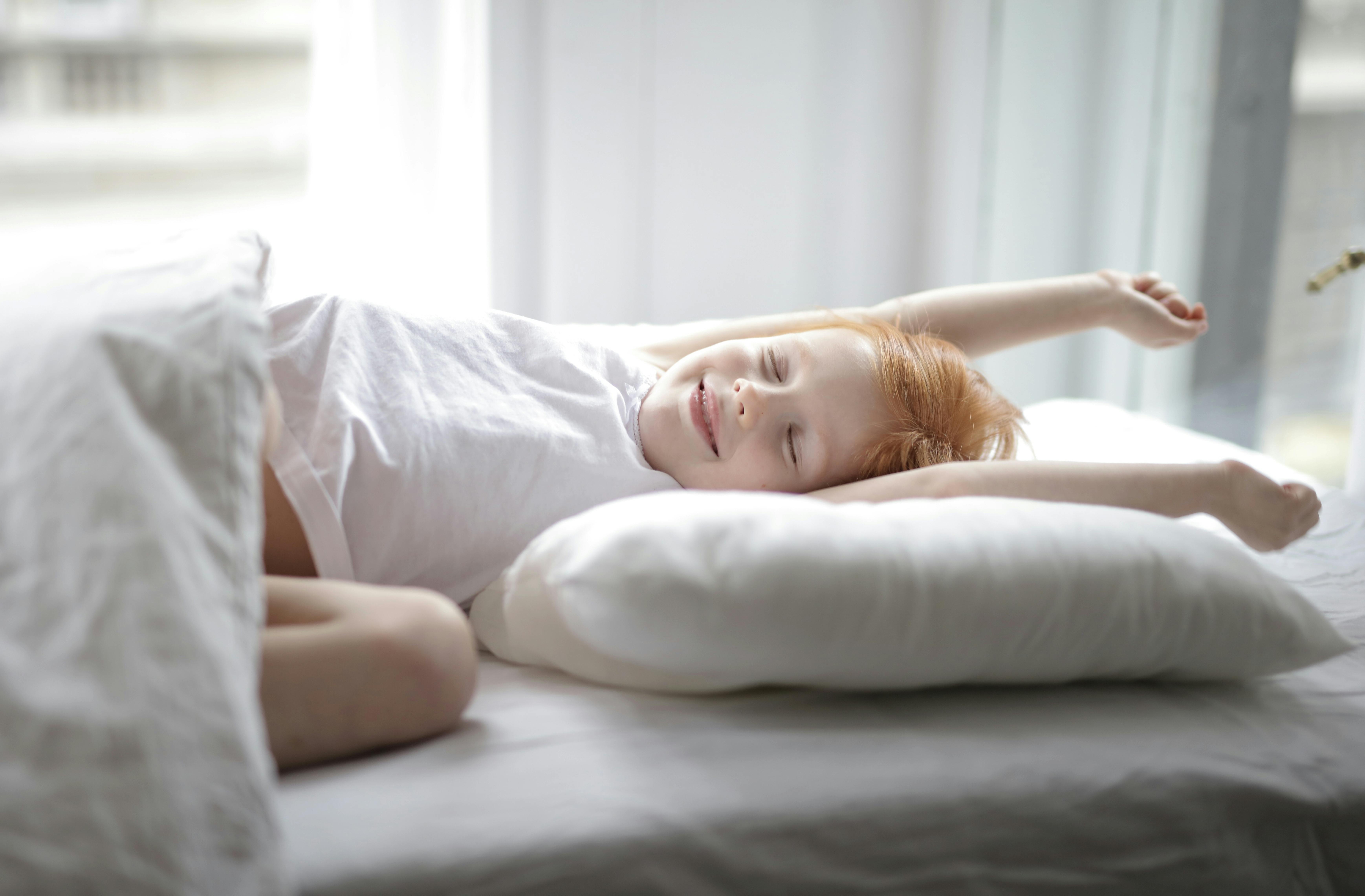 A little girl lying in bed | Source: Pexels