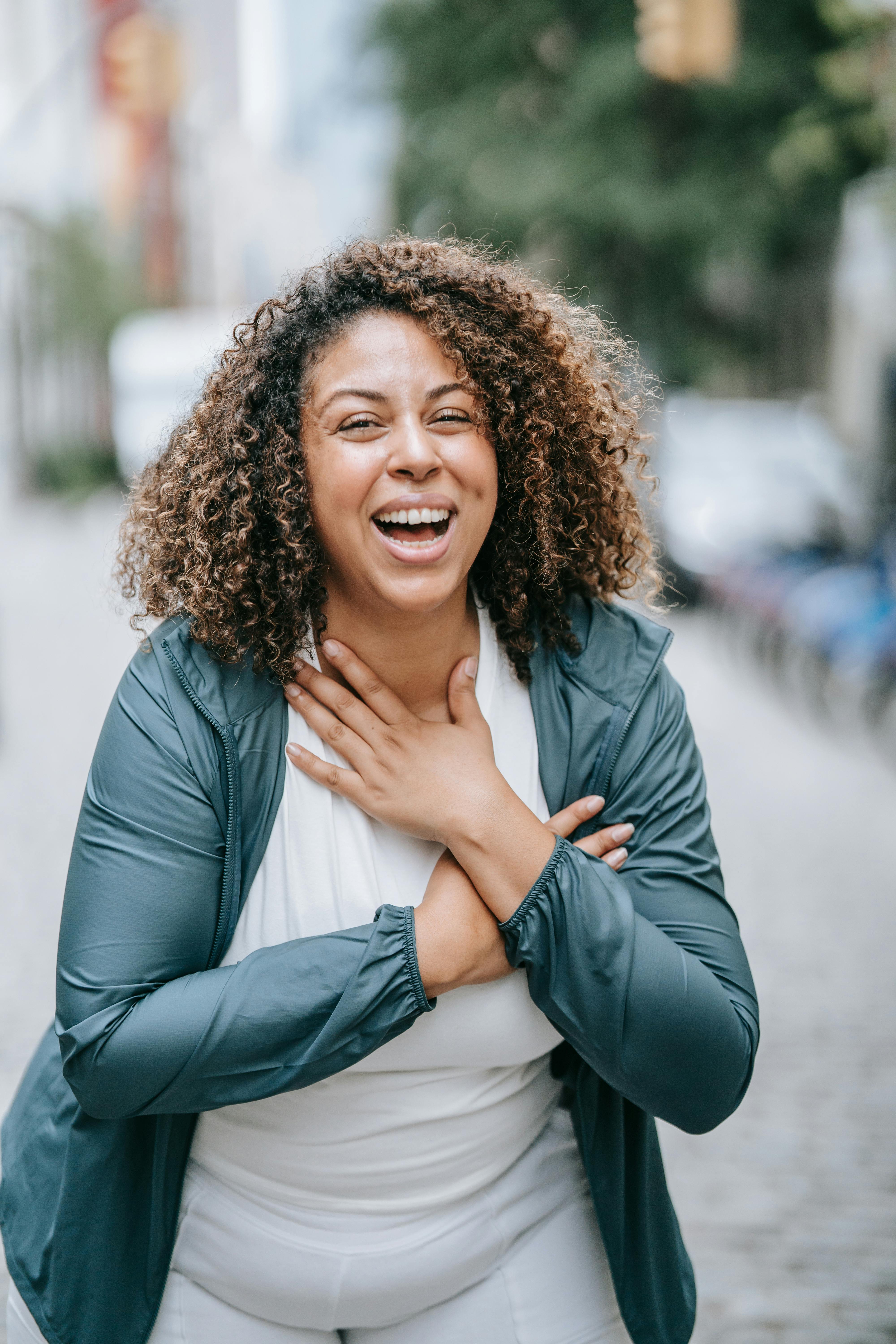 A woman smiling with her hands on her chest | Source: Pexels