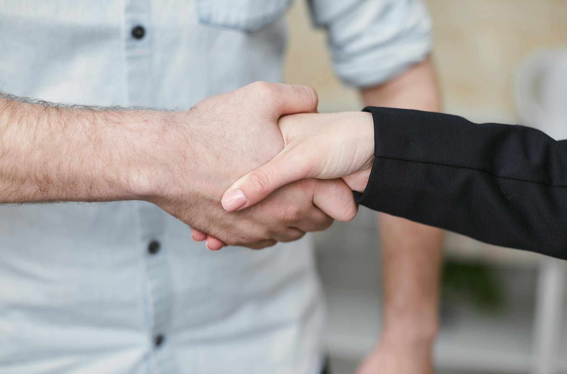 A man and a woman shaking hands | Source: Pexels