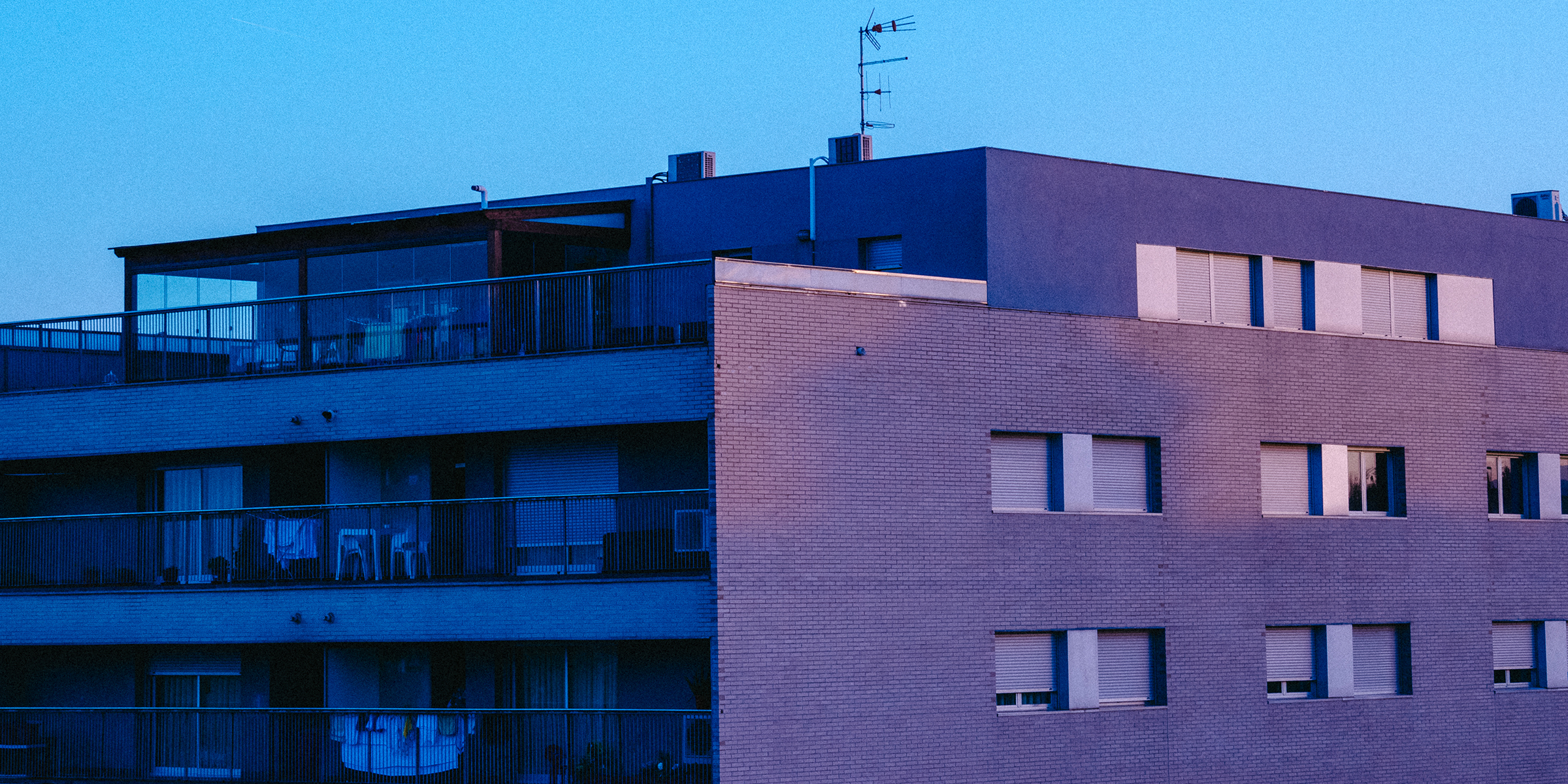 A modern apartment building at dusk | Source: Freepik / leyy