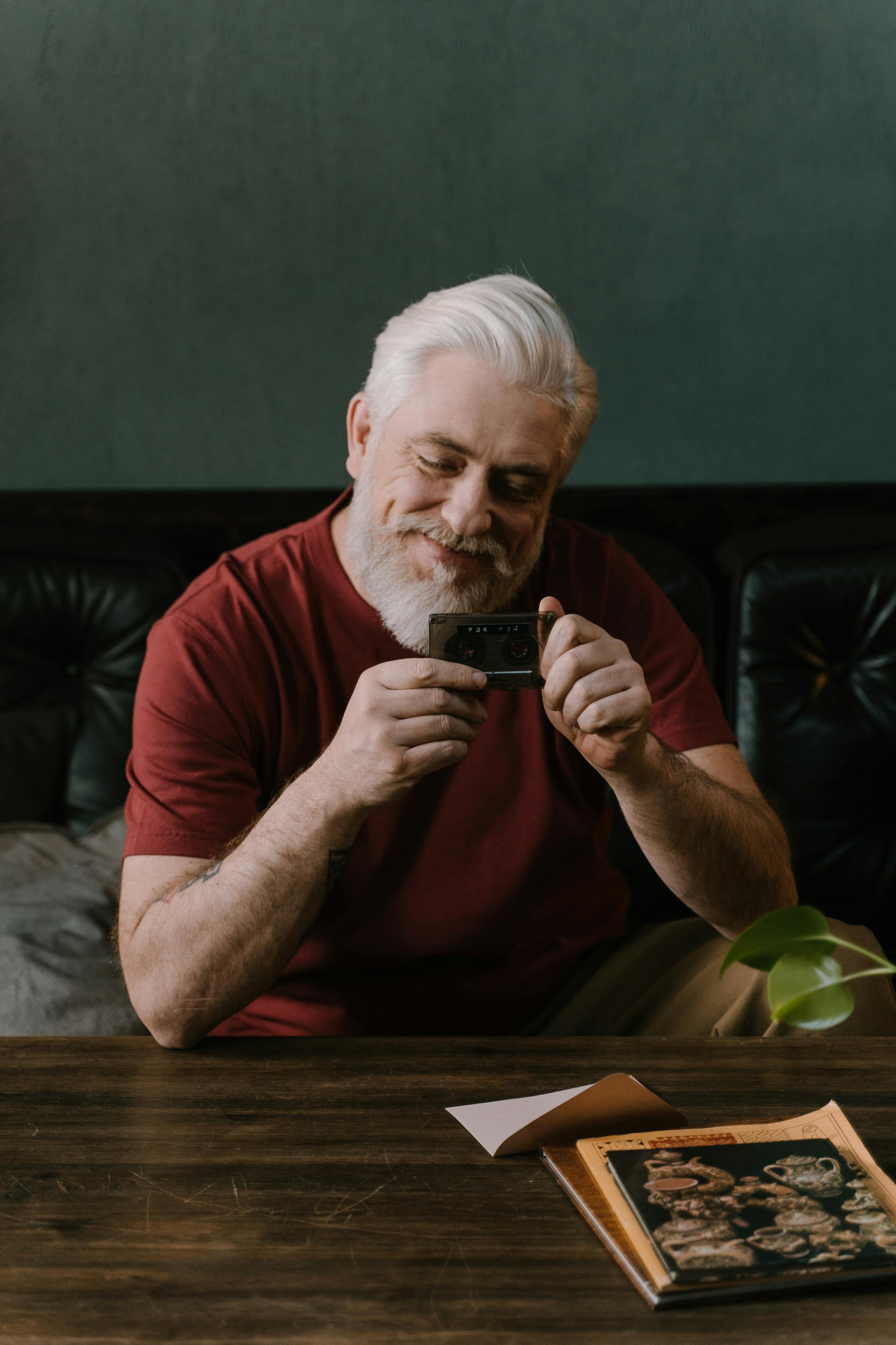 A smiling older man sitting at a table | Source: Pexels