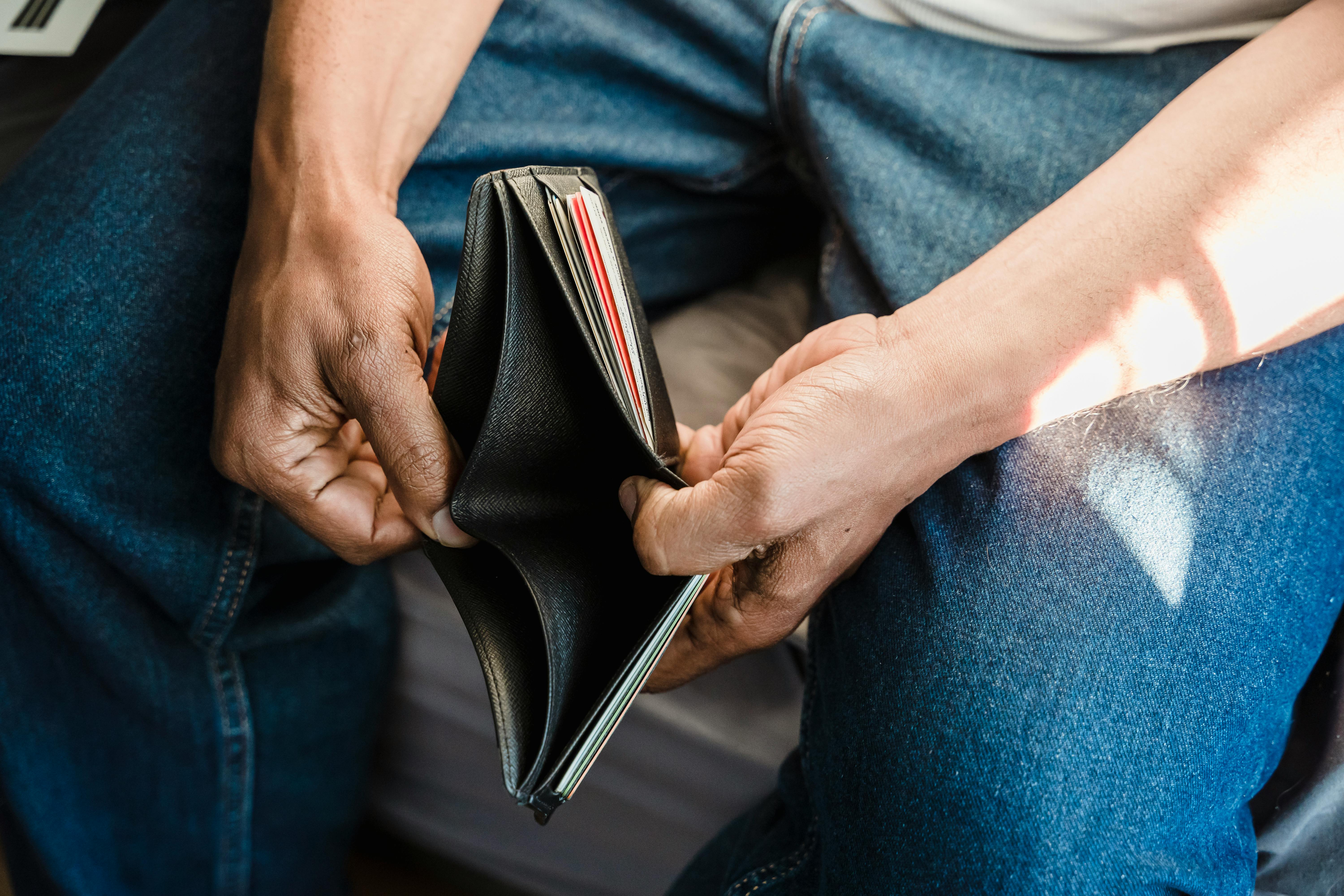 A person looking at an empty wallet | Source: Pexels