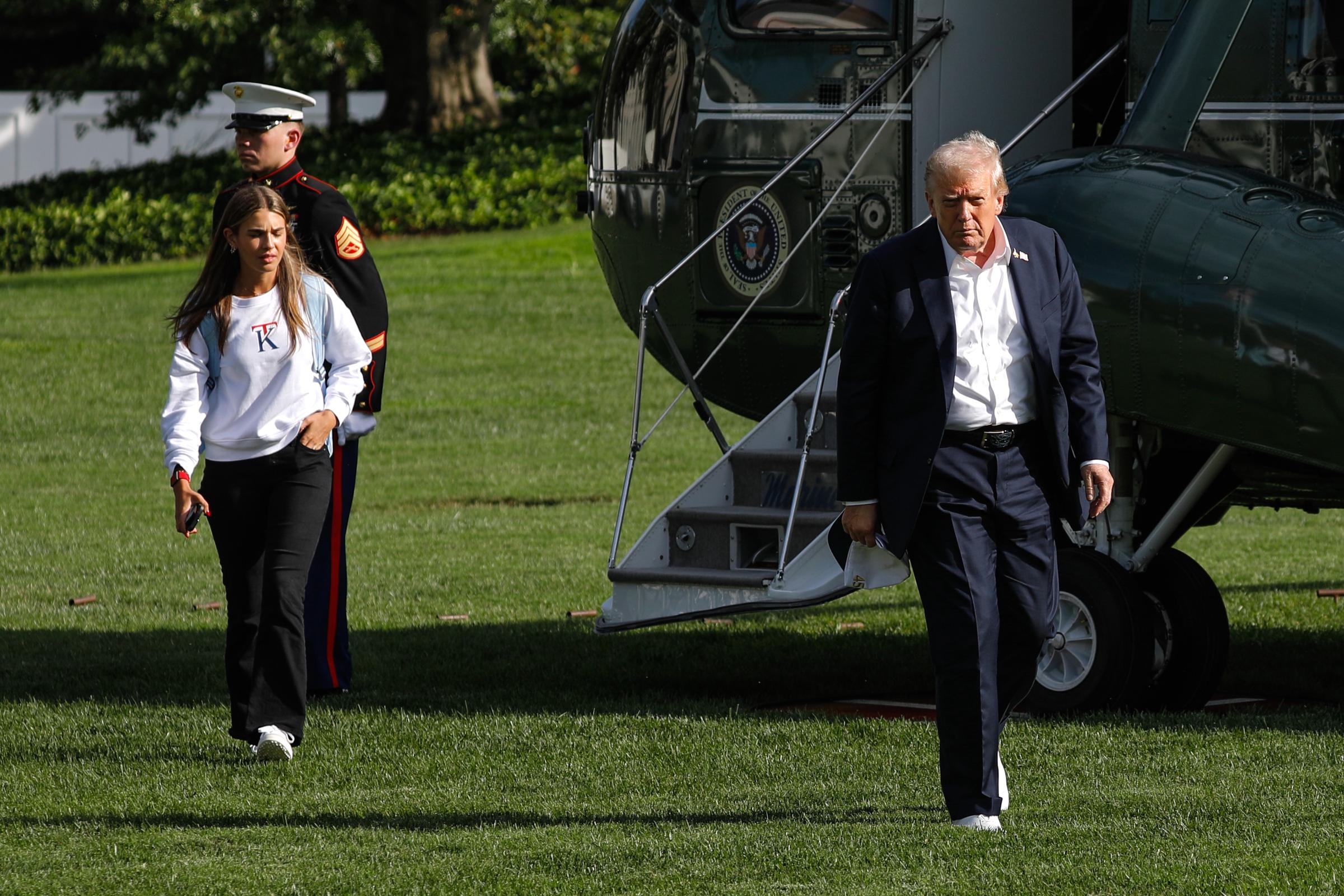 Donald Trump and his granddaughter, Kai Trump, walk on the South Lawn of the White House after arriving on Marine One in Washington, DC, on September 26, 2025, in Washington, DC. | Source: Getty Images