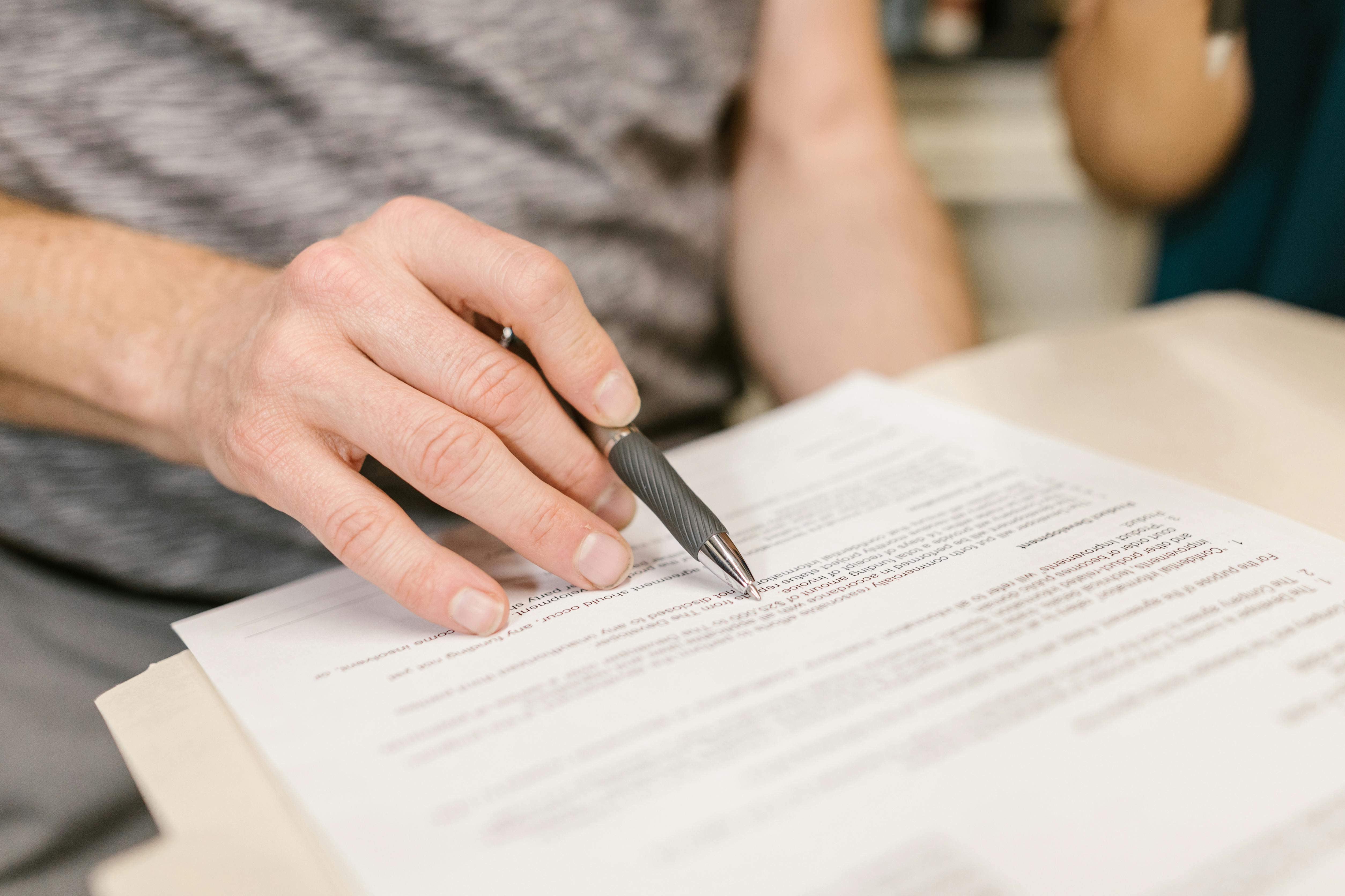 A person signing documents | Source: Pexels