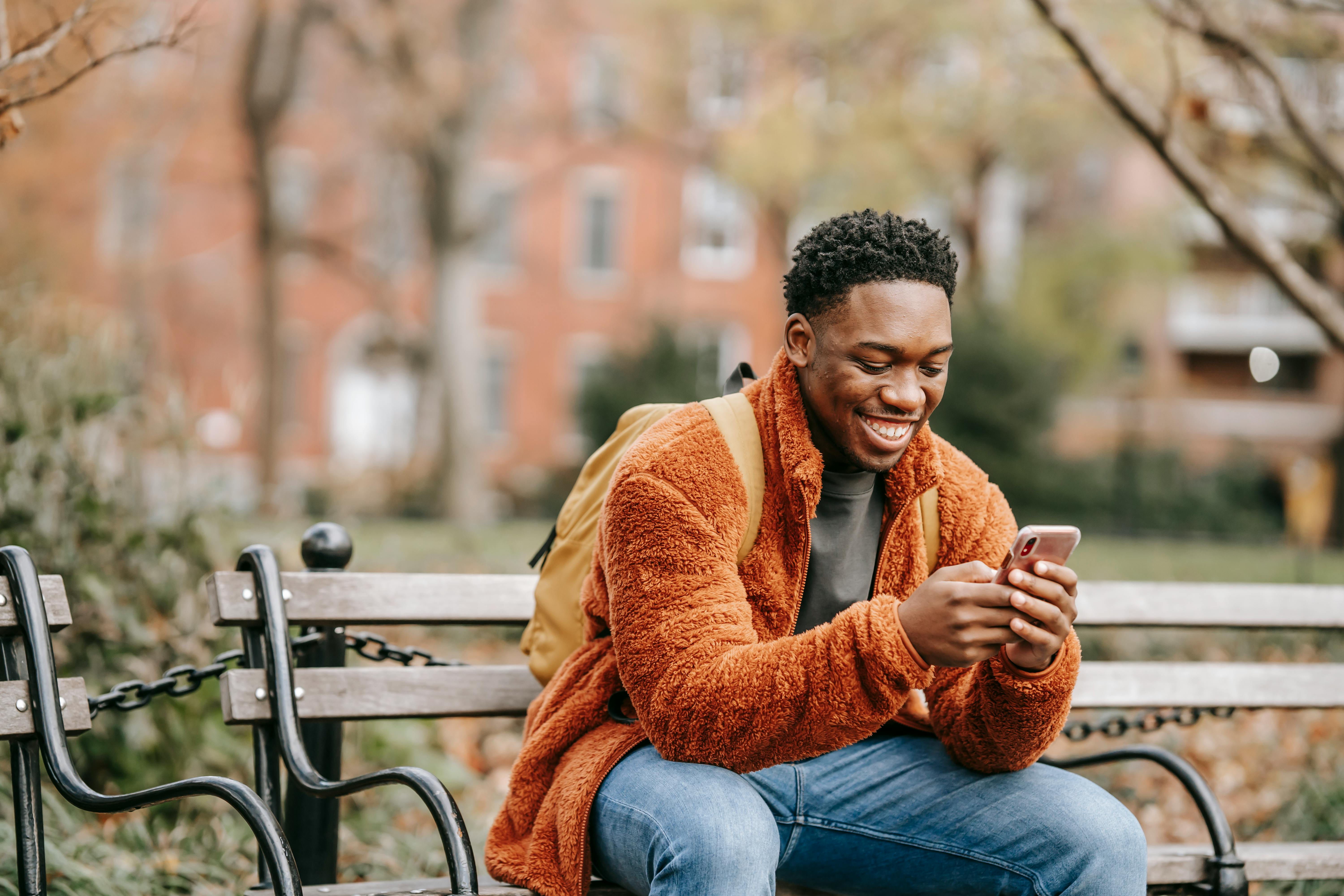 A man smiling at his phone | Source: Pexels