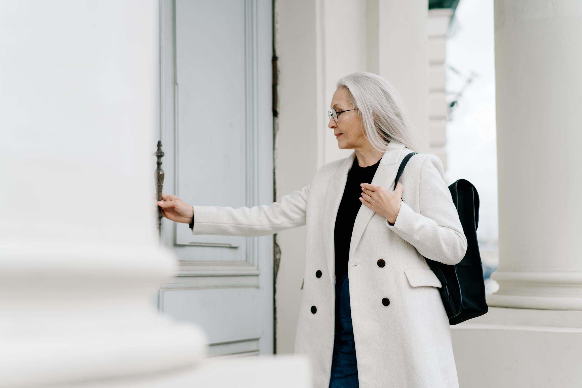 Senior woman holding a door handle | Source: Pexels