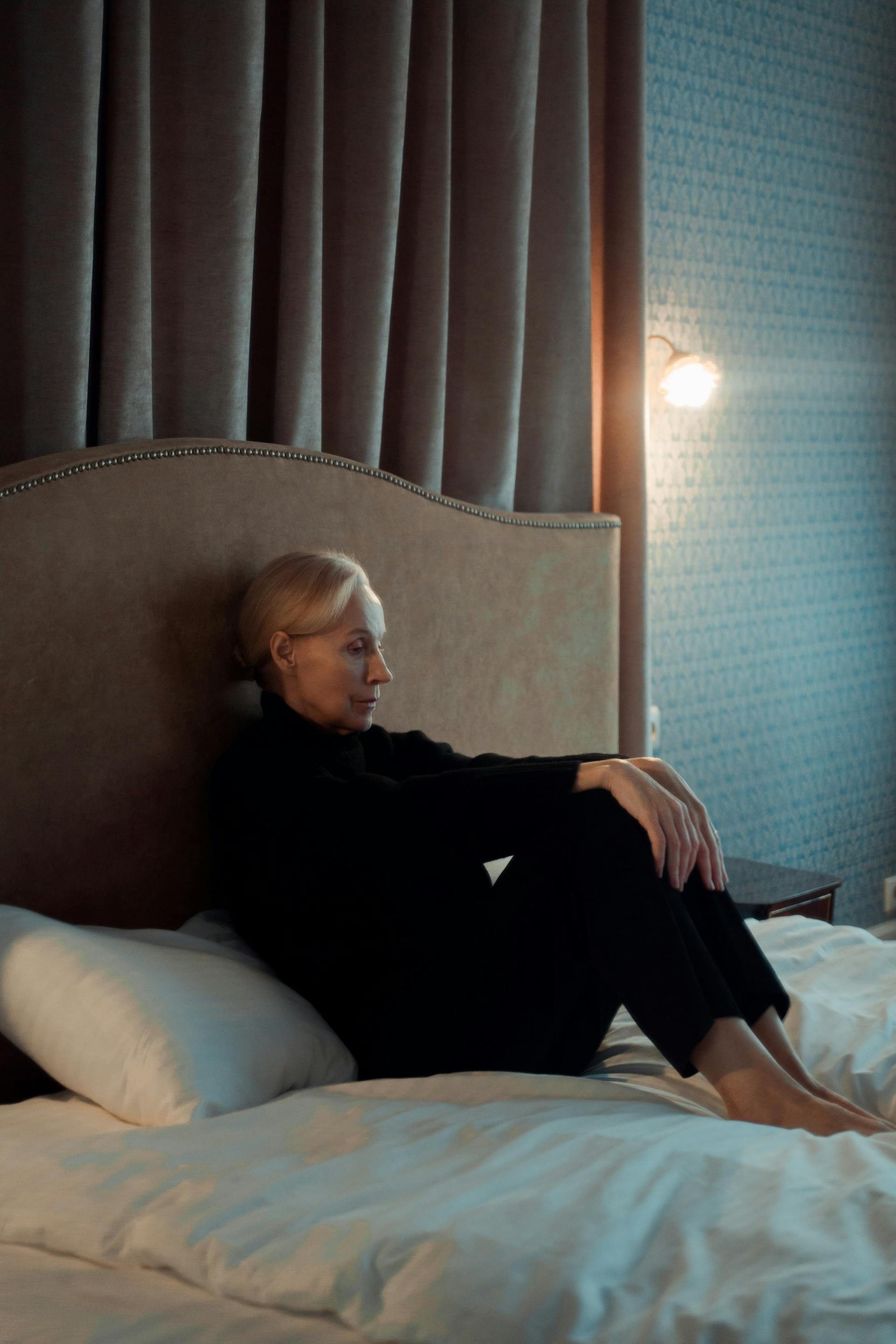 A woman sitting on her bed | Source: Pexels