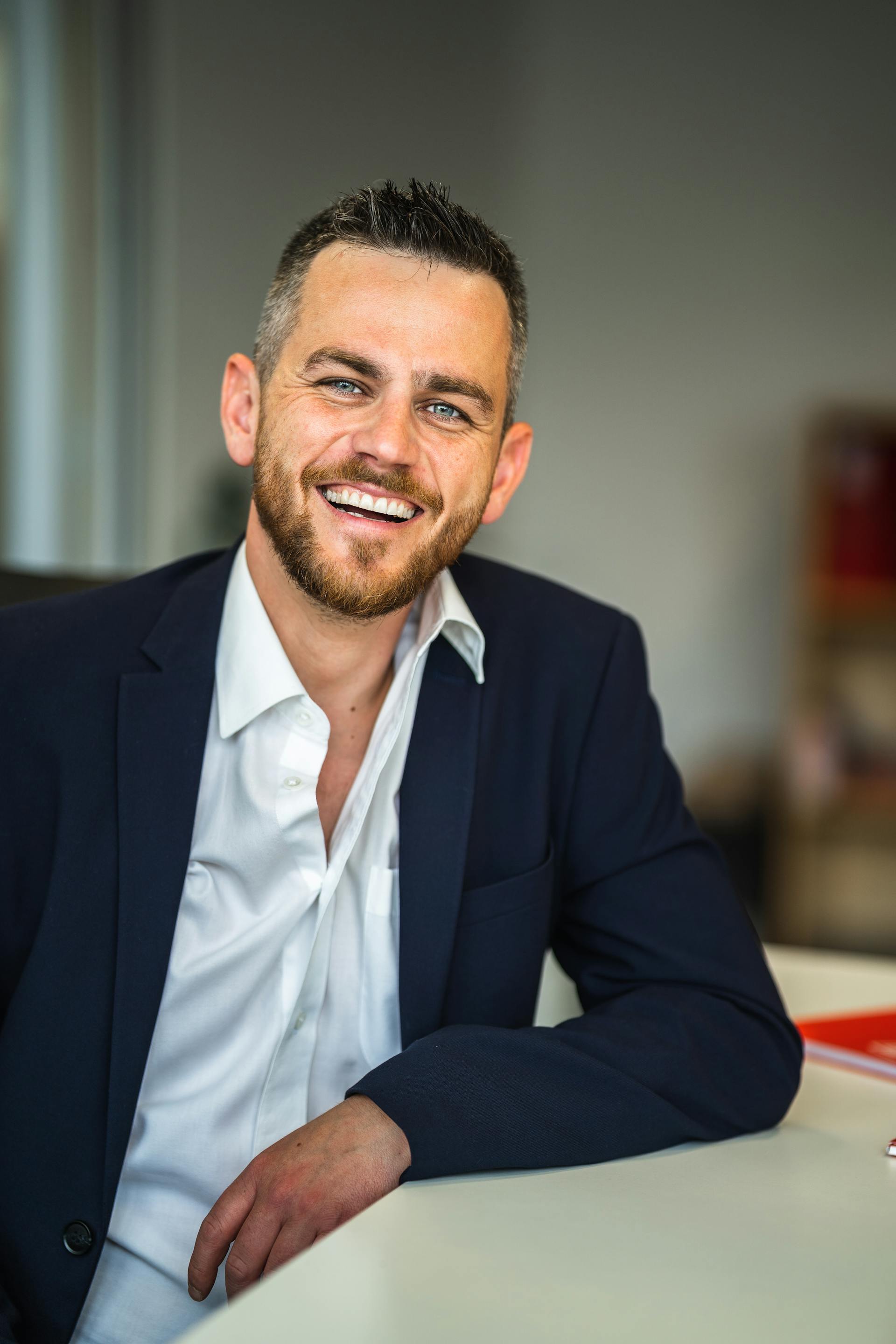 A man in a suit laughing in an office | Source: Pexels