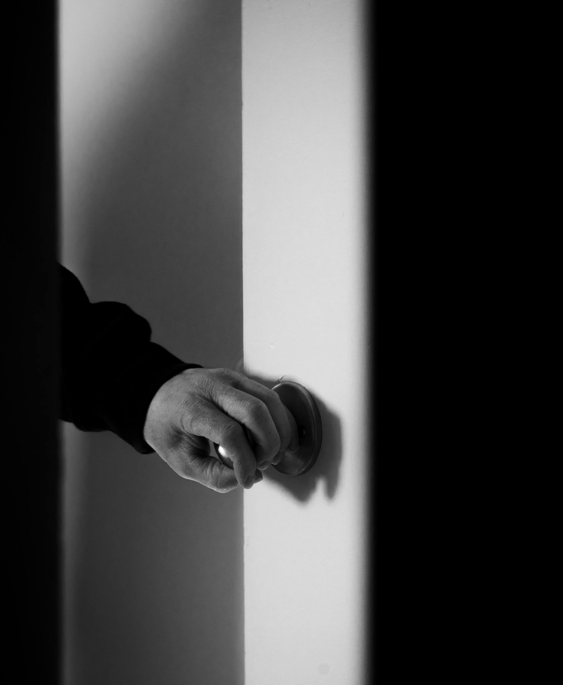 A man's hand on a door handle | Source: Pexels