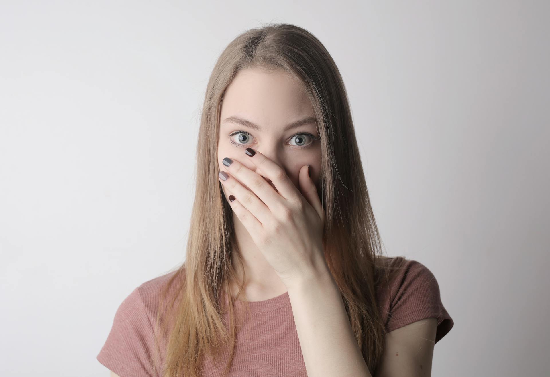 A stunned woman covering her mouth with her hand | Source: Pexels