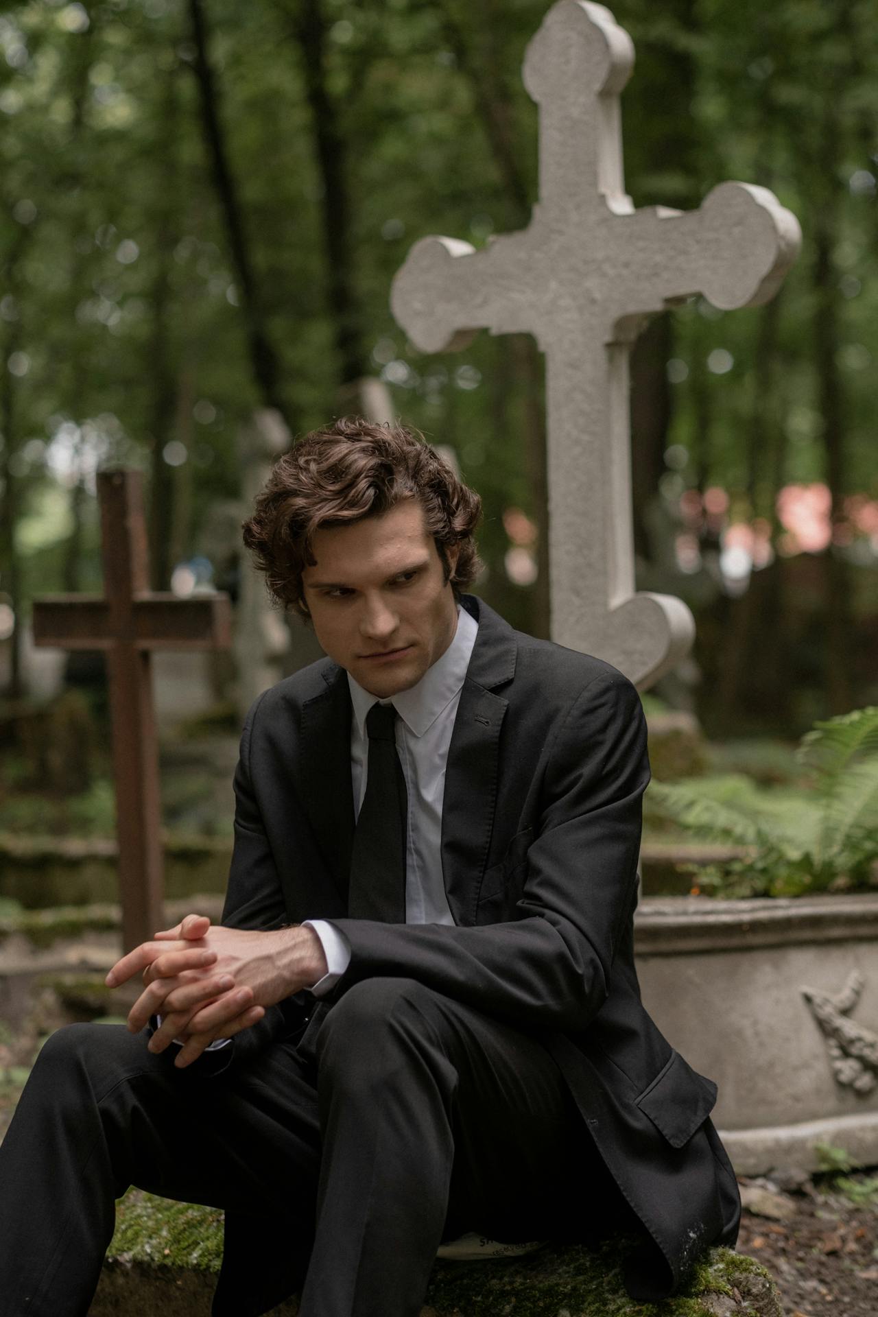 A man sitting in a cemetery | Source: Pexels
