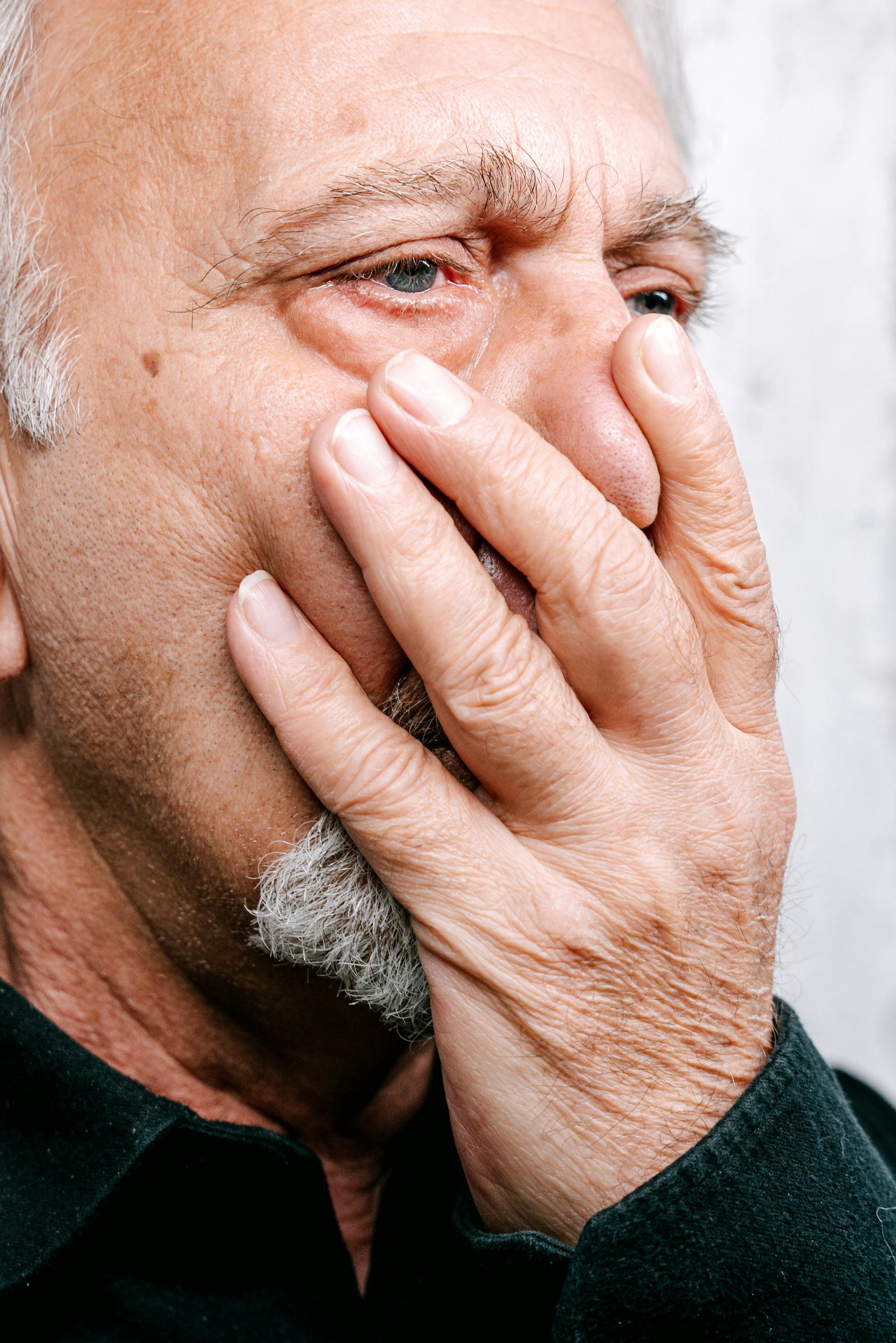 A man covering his mouth with one hand | Source: Pexels