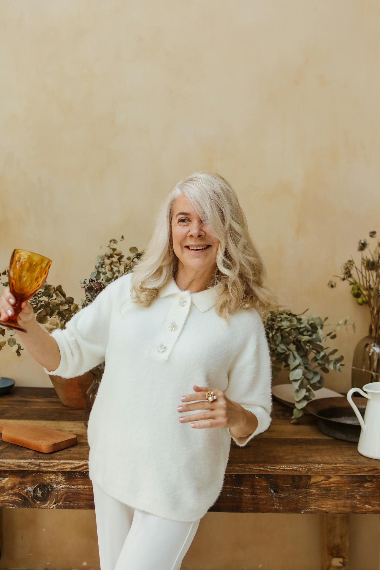 A smiling senior woman holding a goblet | Source: Pexels