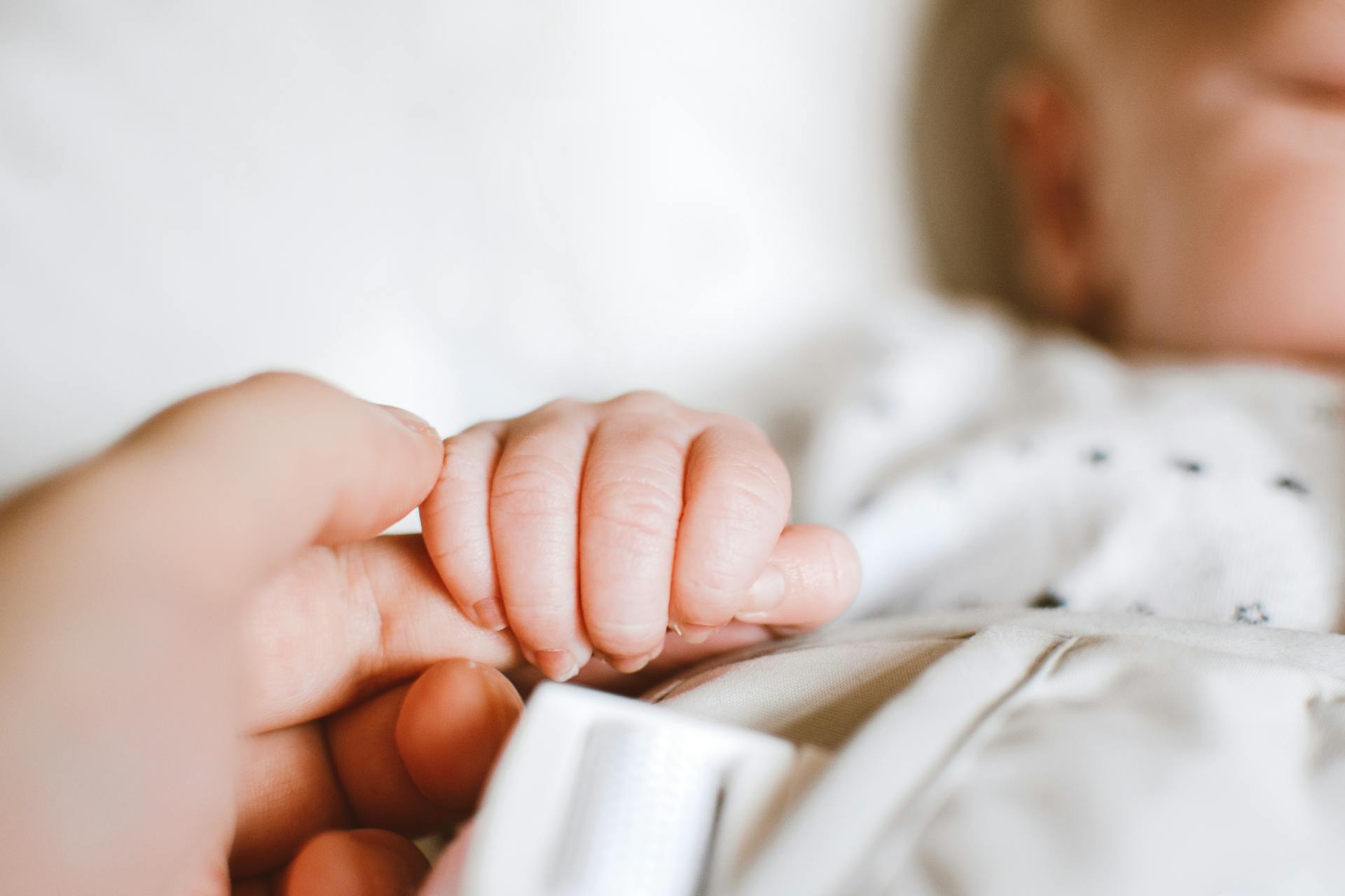 A baby clasping an adult's finger | Source: Pexels