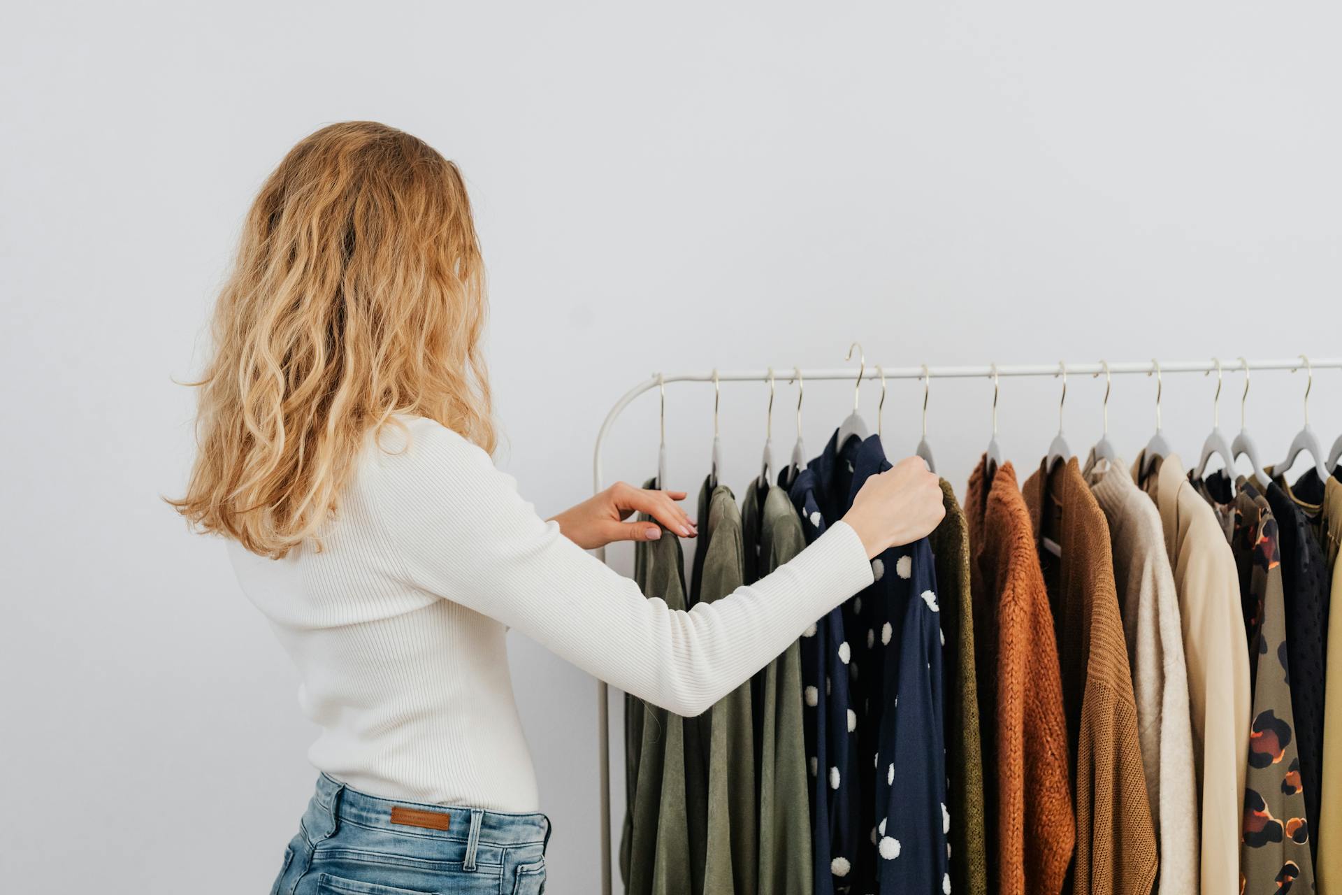 A woman hanging clothes on a rack | Source: Pexels