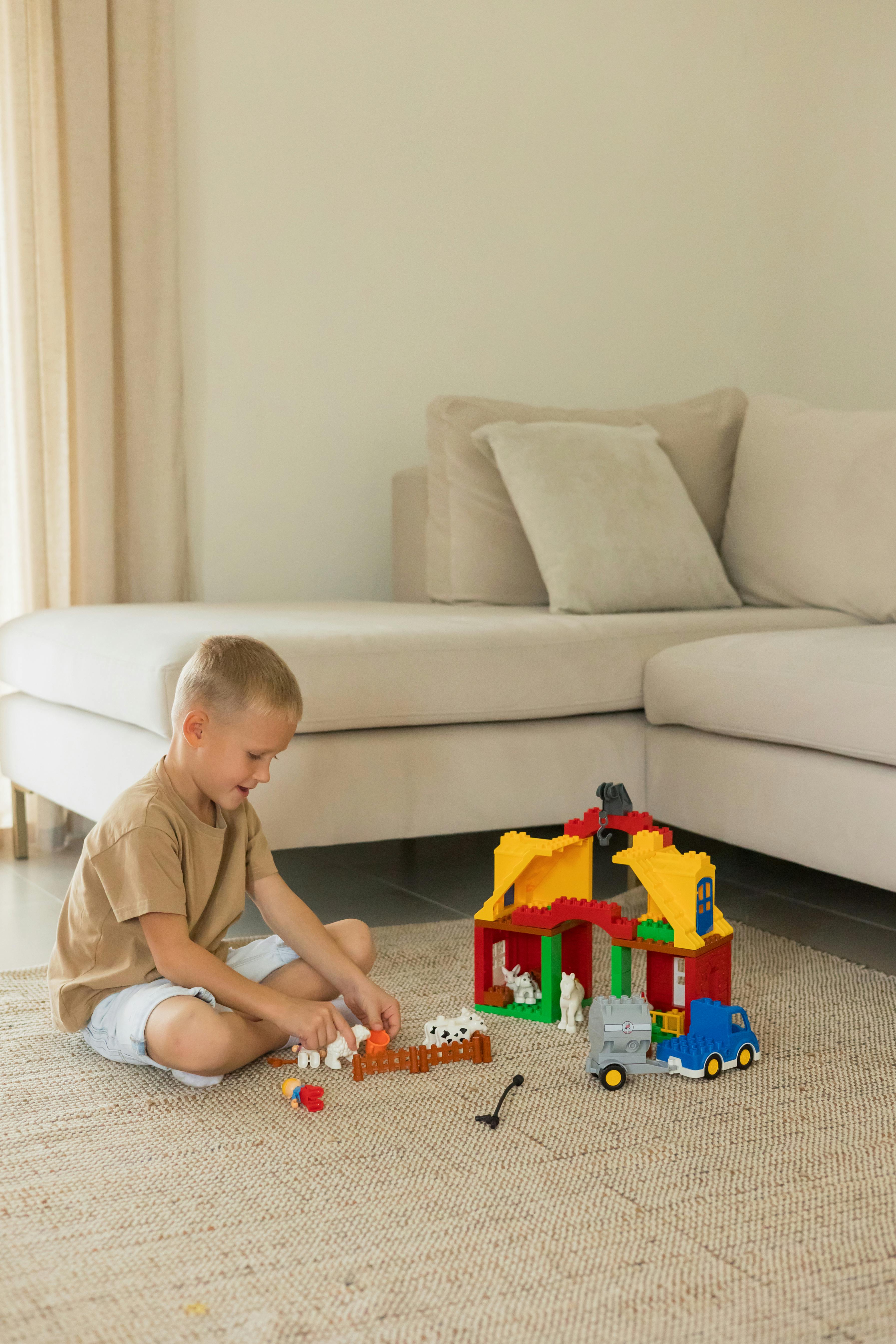 A little boy playing on a carpet | Source: Pexels