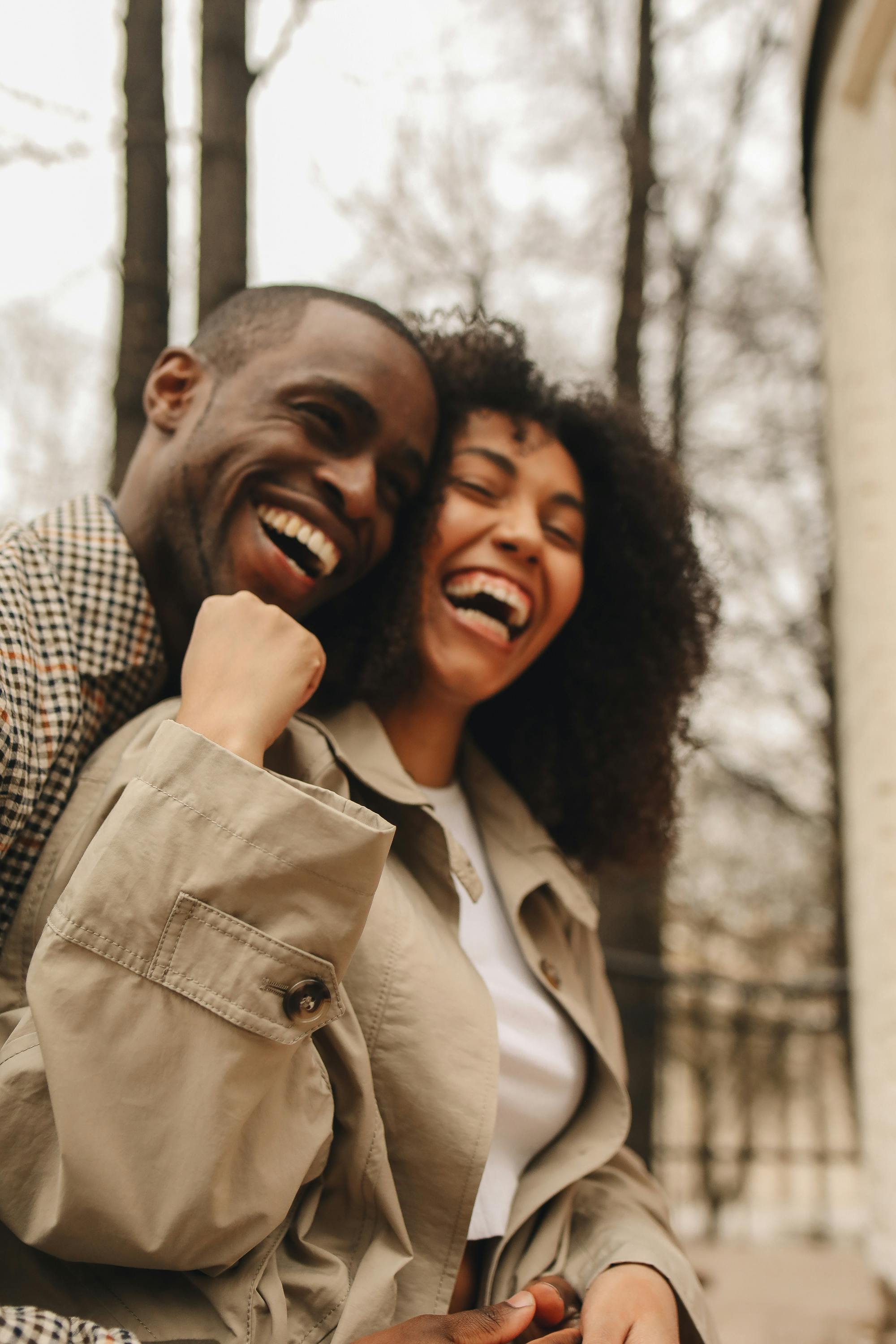 A couple laughing in an embrace | Source: Pexels