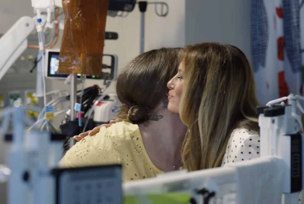 Melania Trump gives someone a kiss on the cheek as she visits pediatric patients at the National Children's Hospital in Washington D.C. on July 3, 2025 | Source: Instagram/flotus