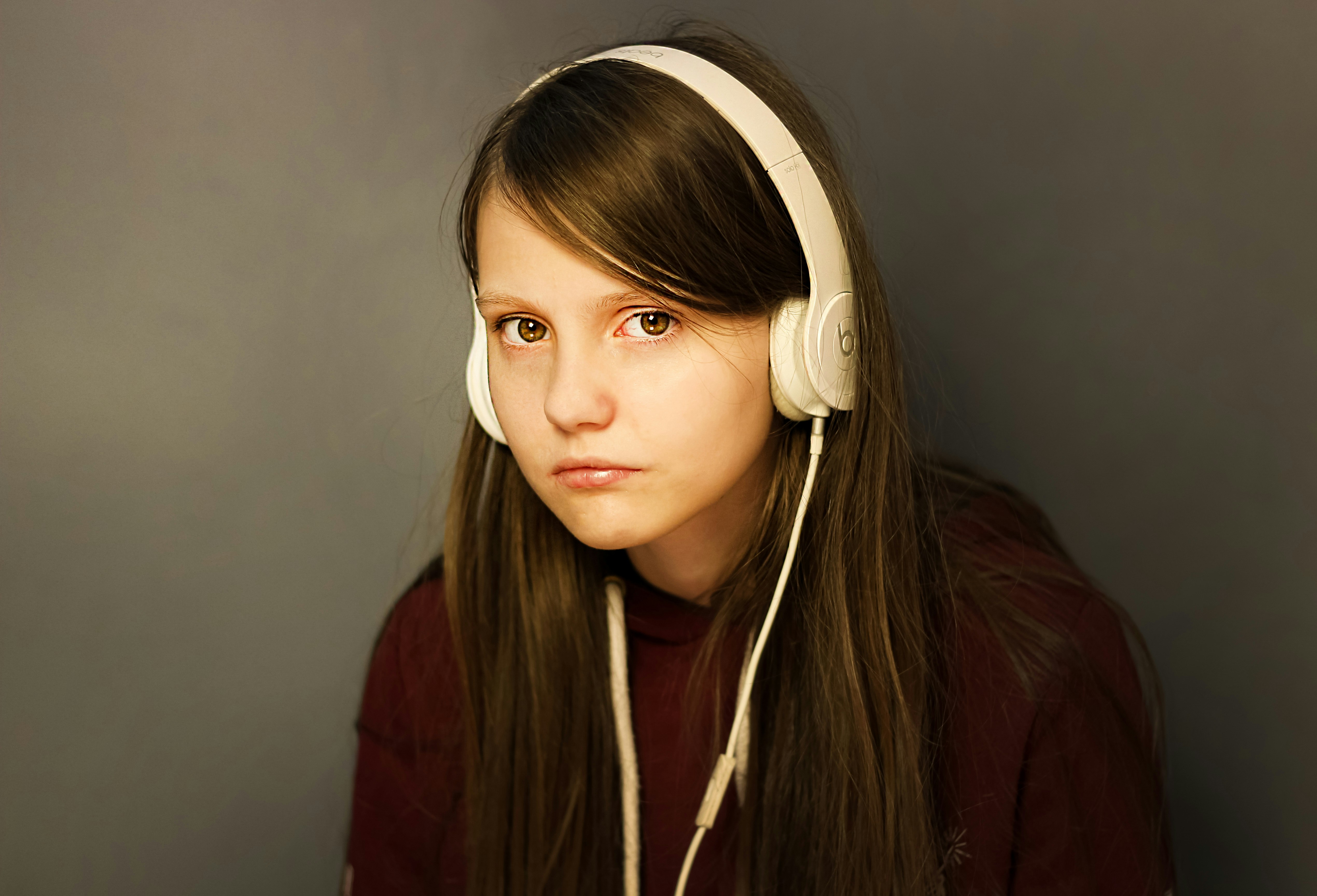 An emotional teenage girl wearing headphones | Source: Unsplash