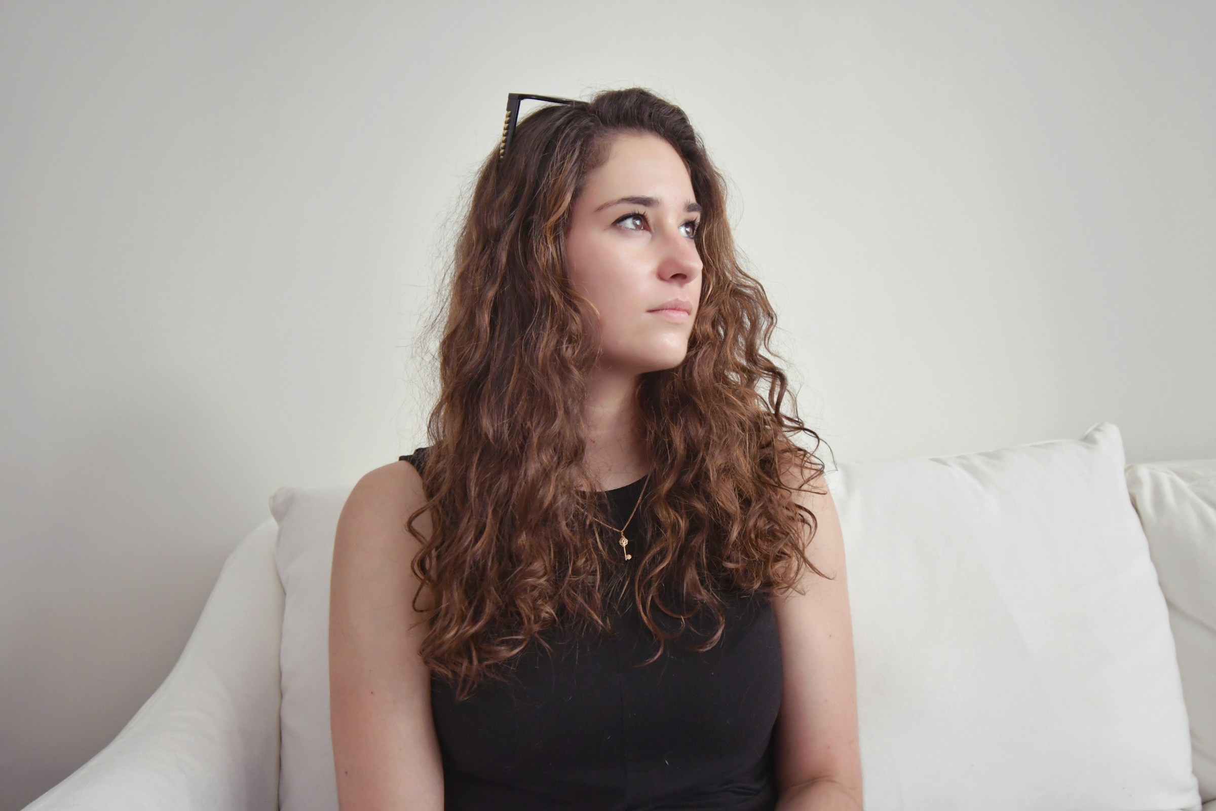 A woman sitting on a sofa and looking sideways | Source: Unsplash