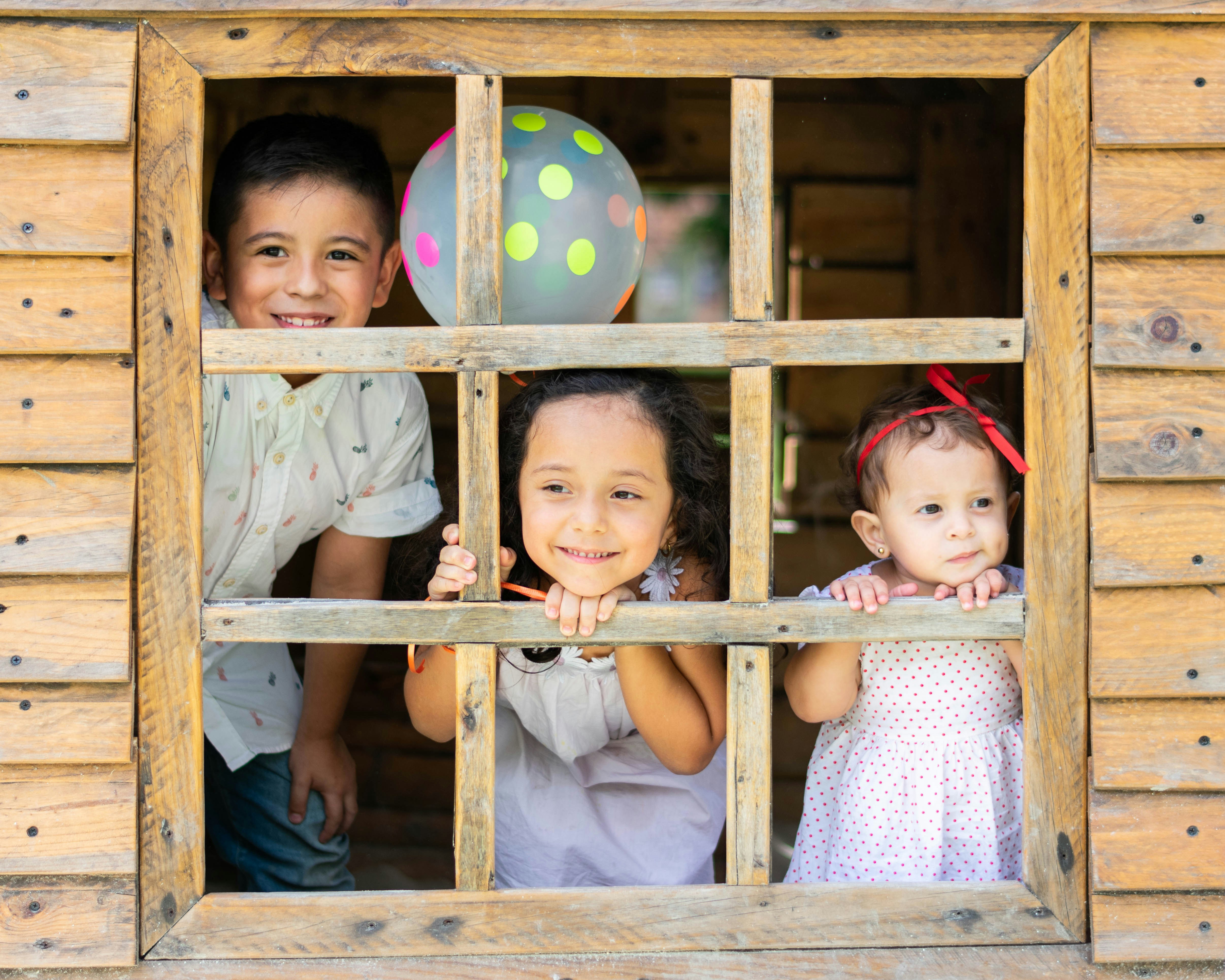 Children at the window of a cabin | Source: Unsplash