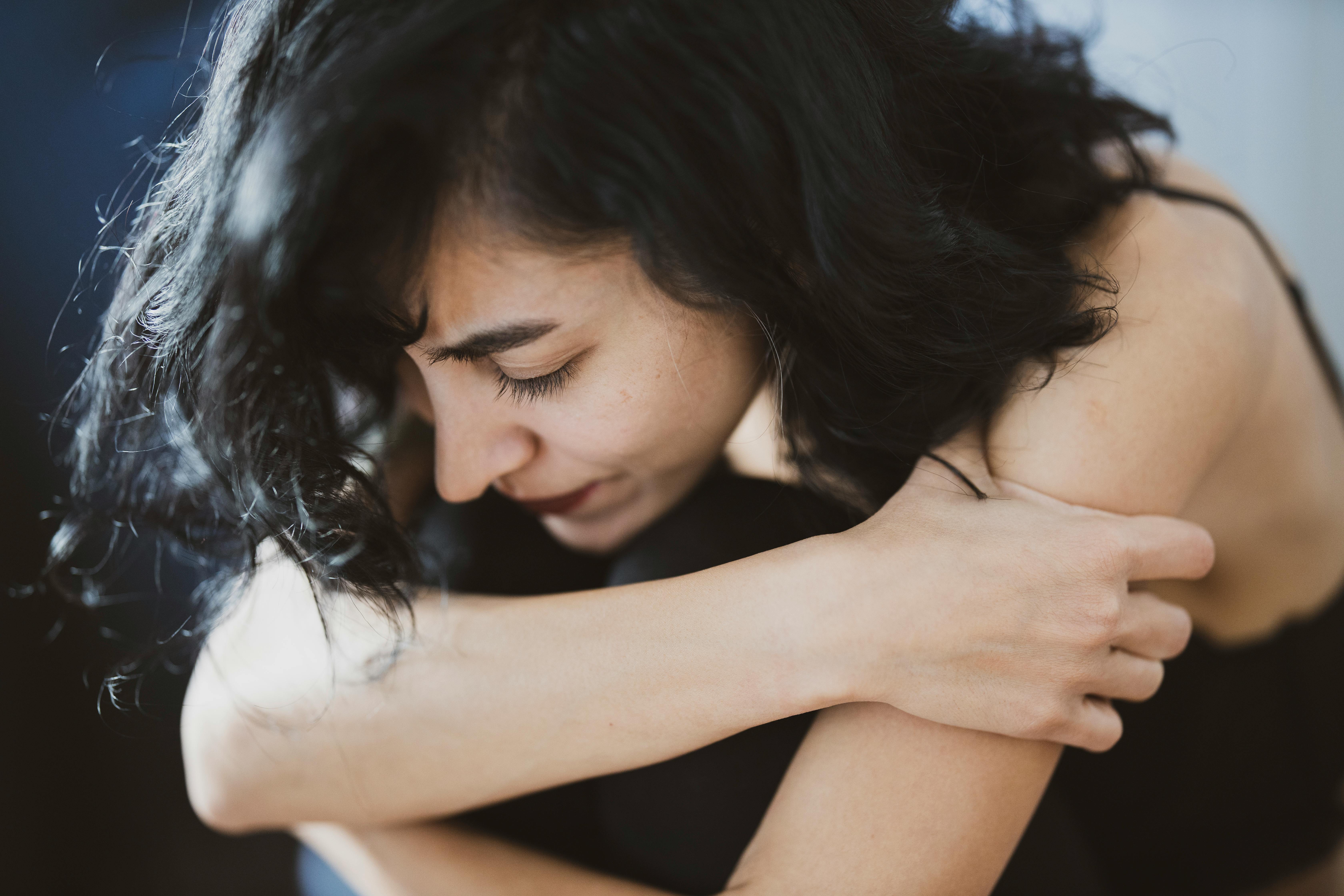 An upset woman holding herself | Source: Pexels