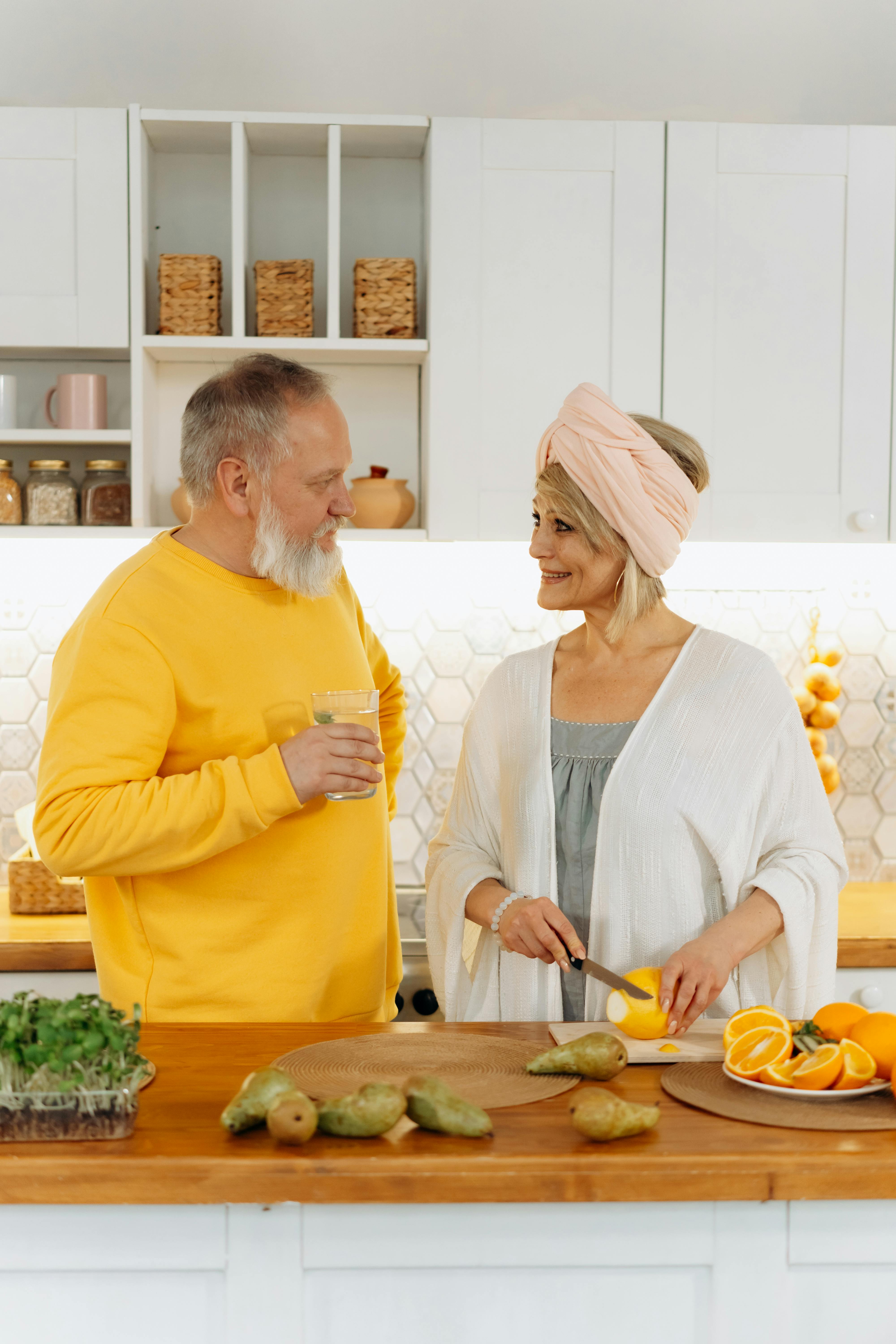 A smiling older couple in a kitchen | Source: Pexels