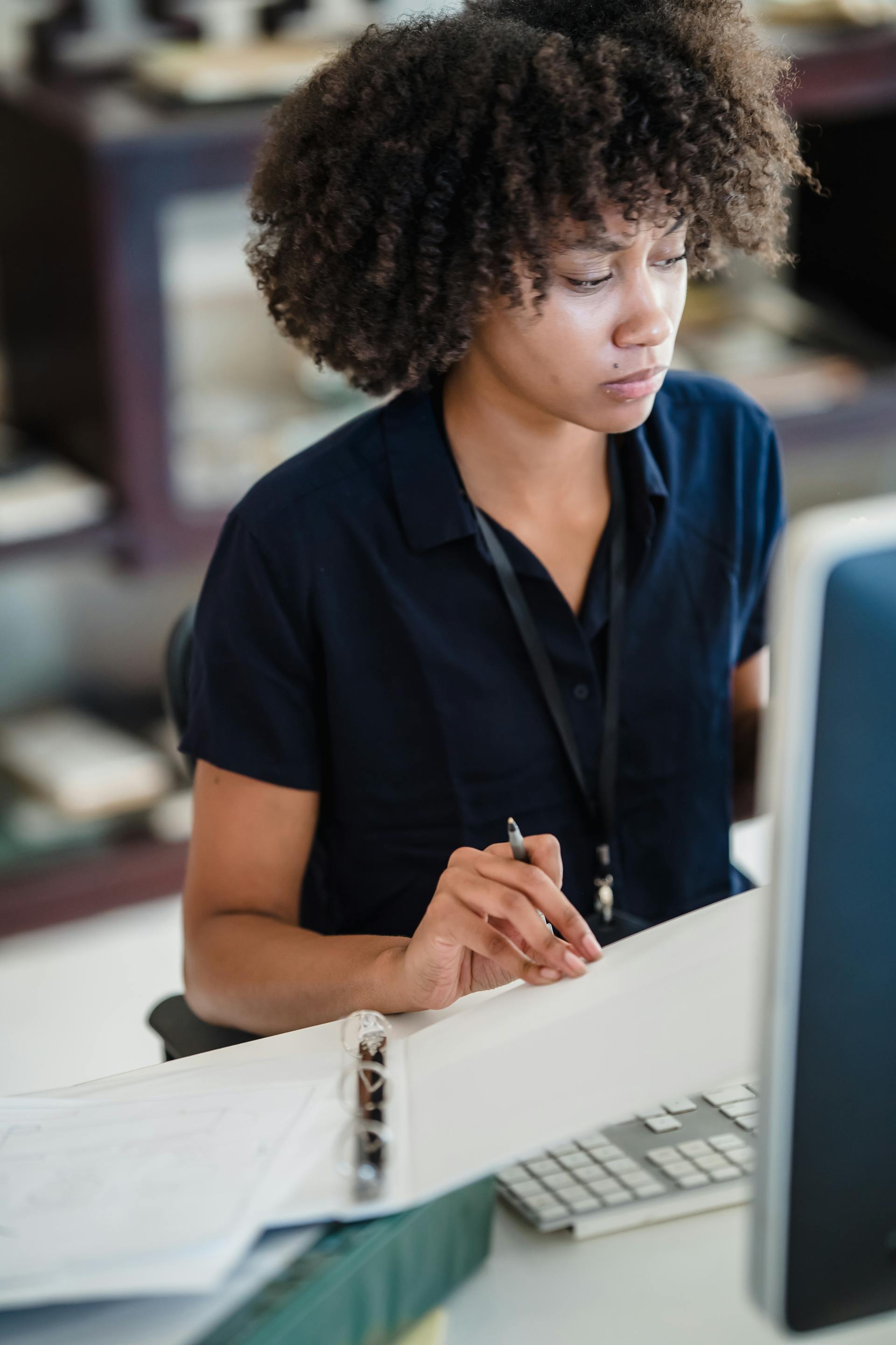 A woman sitting at a work desk looking worried | Source: Pexels