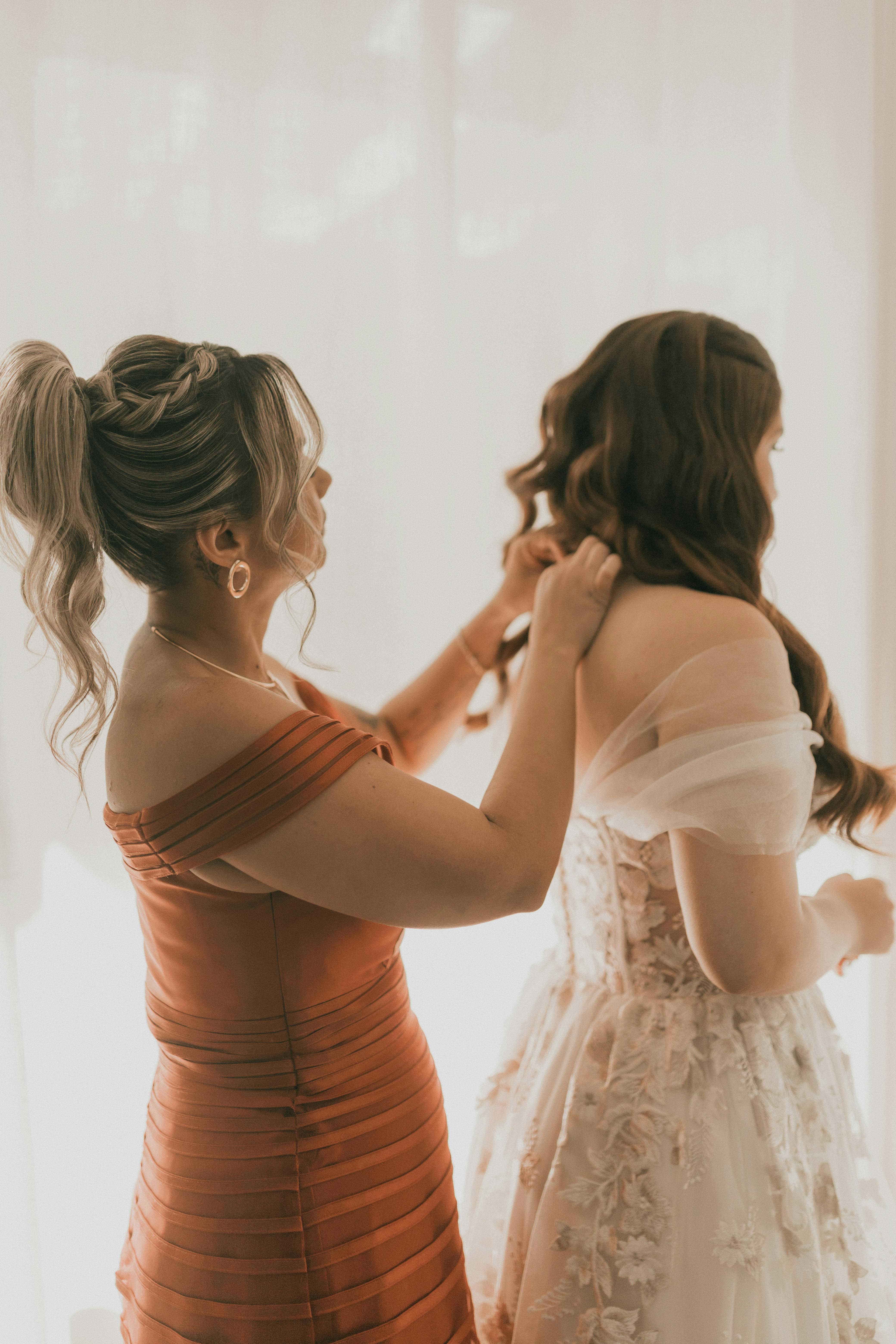 A bridesmaid helping a bride | Source: Pexels