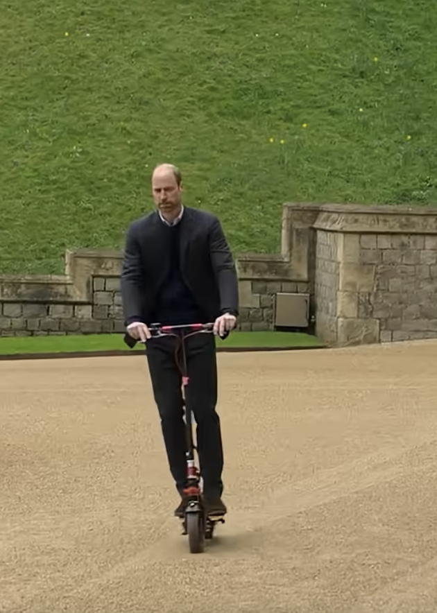 Prince William riding his scooter on his way to an interview in the Windsor Castle grounds | Source: youtube/appletv