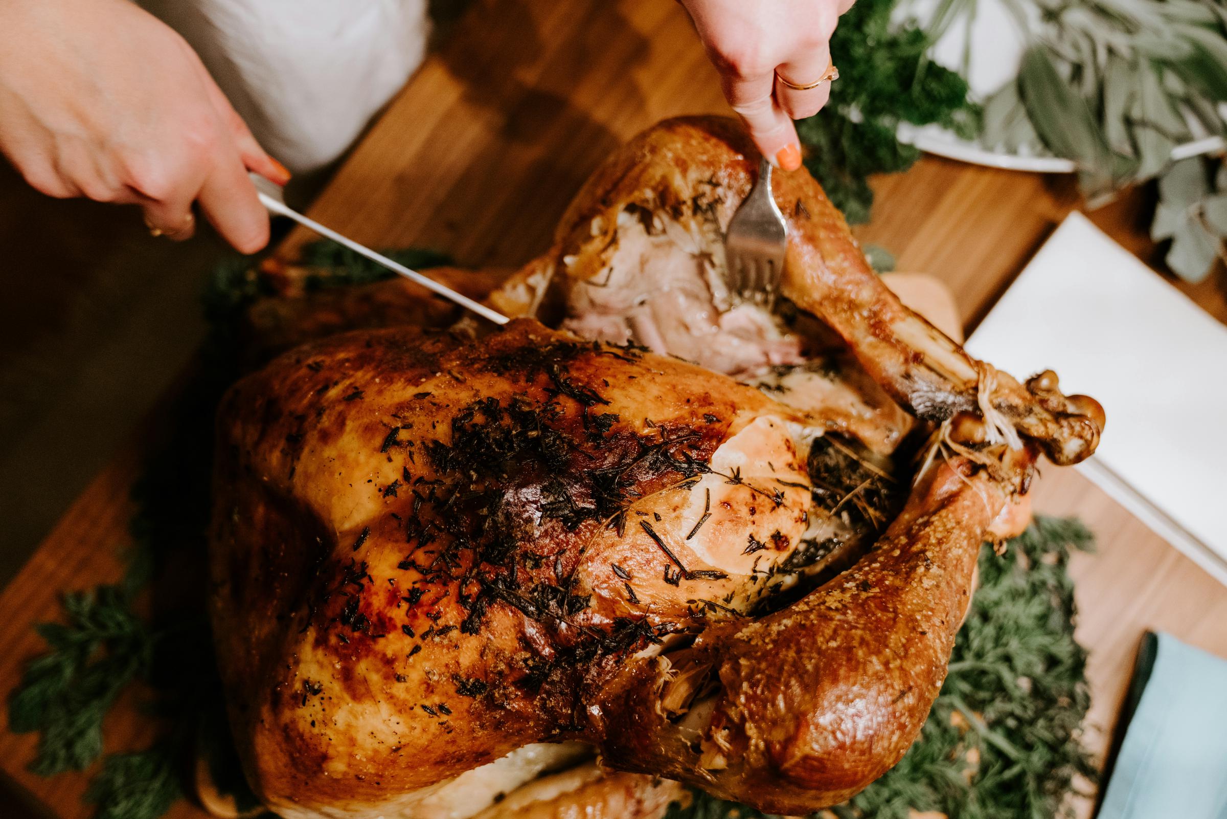 A person cutting into a roast chicken | Source: Unsplash