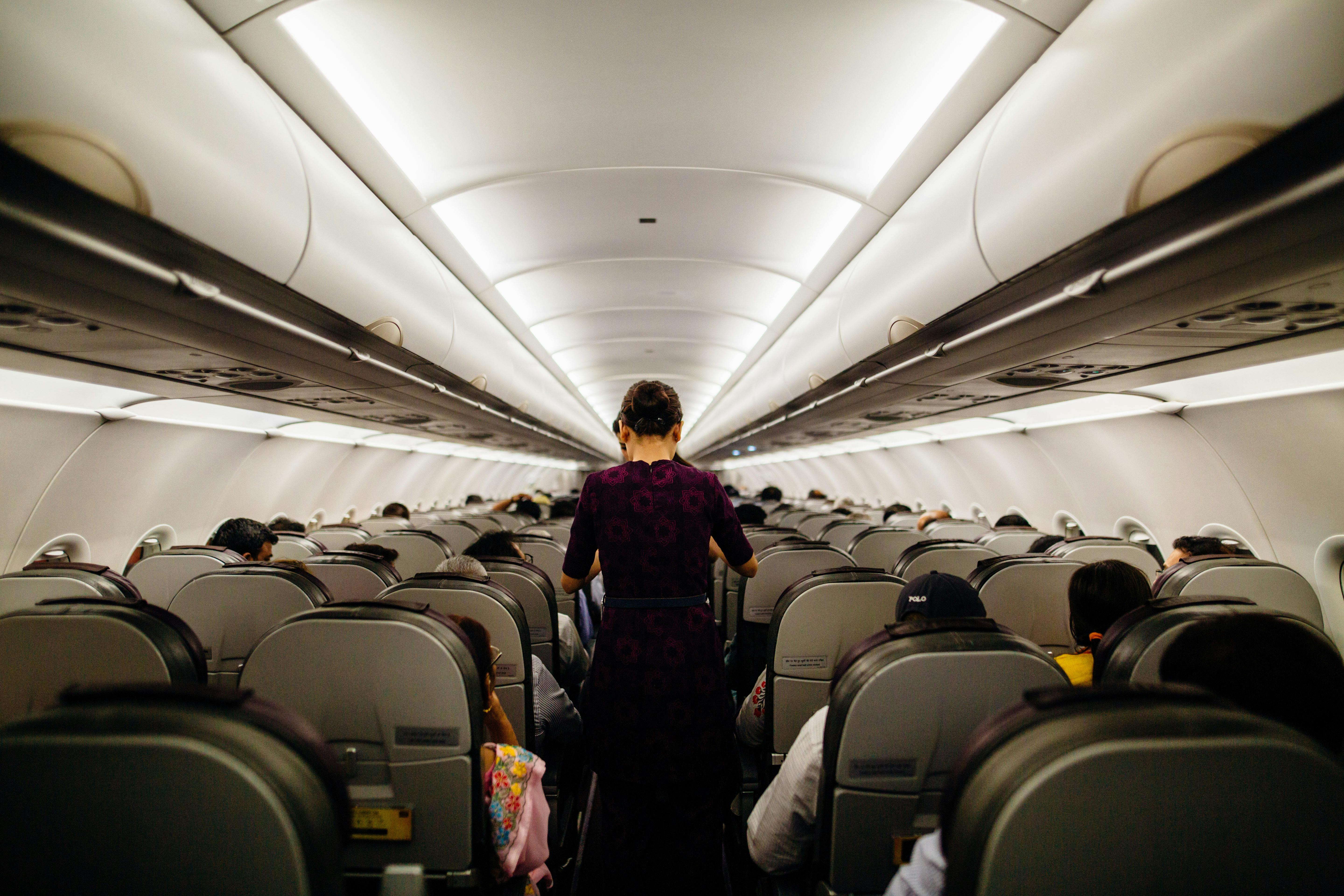 Une hôtesse de l'air dans l'allée d'un avion | Source : Pexels