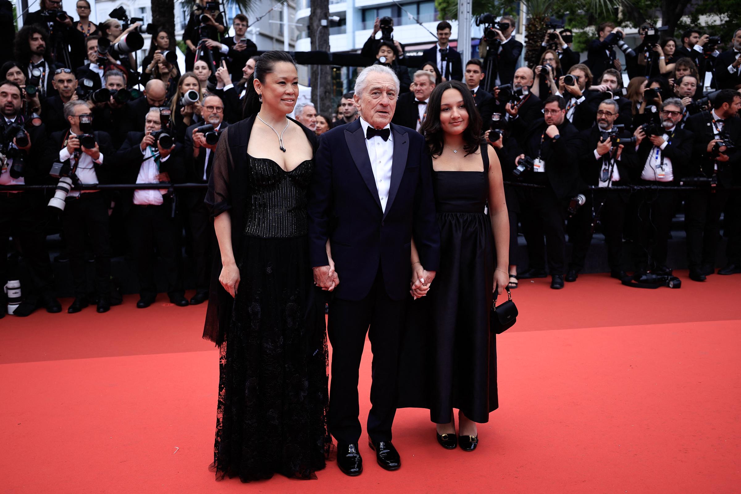 Robert De Niro (C), his partner Tiffany Chen and his child Helen De Niro arrive for the Opening Ceremony and the screening of the film "Partir un Jour" (Bye Bye) presented out of competition at the 78th edition of the Cannes Film Festival on May 13, 2025 in southern France. | Source: Getty Images