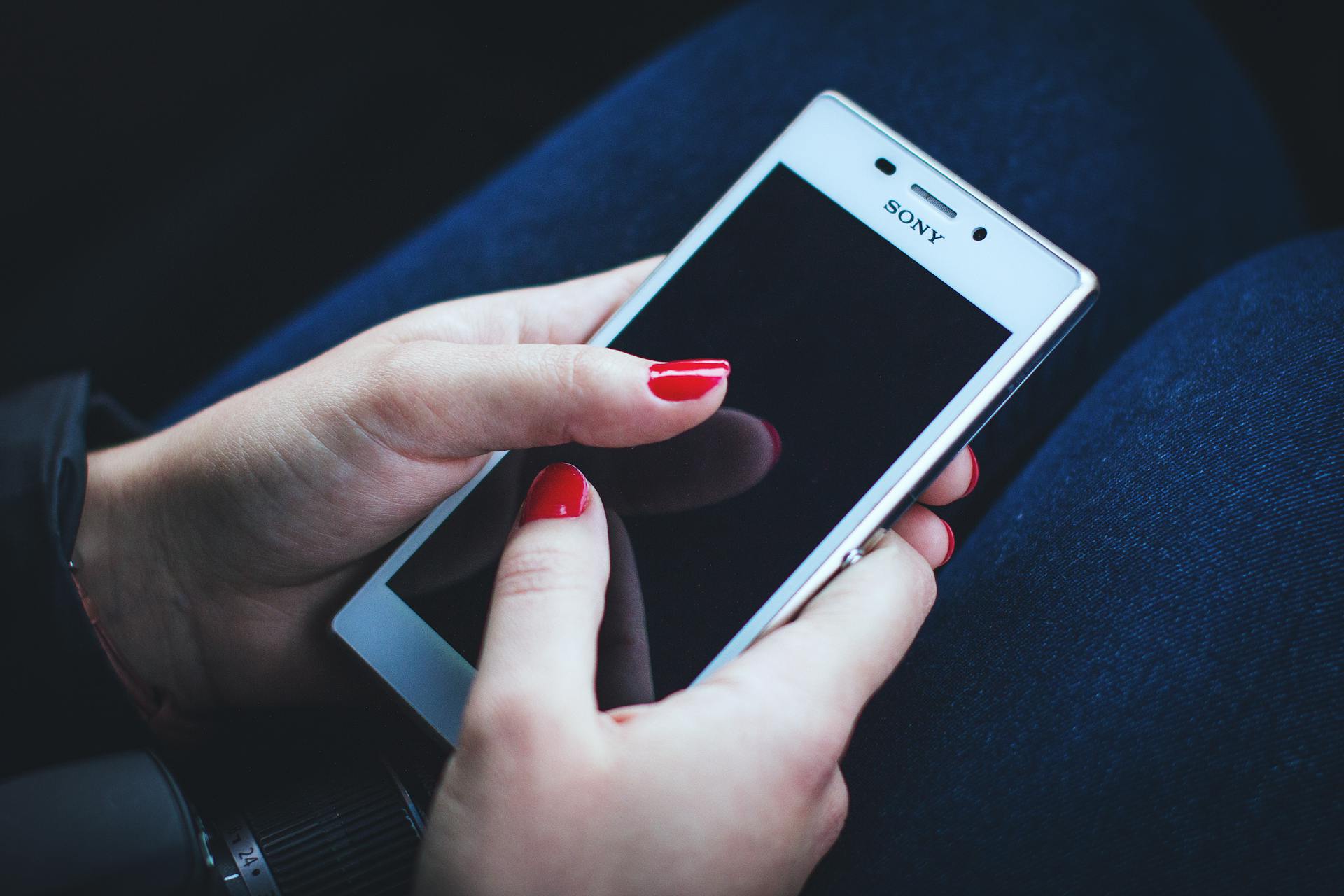 A woman holding a cell phone | Source: Pexels