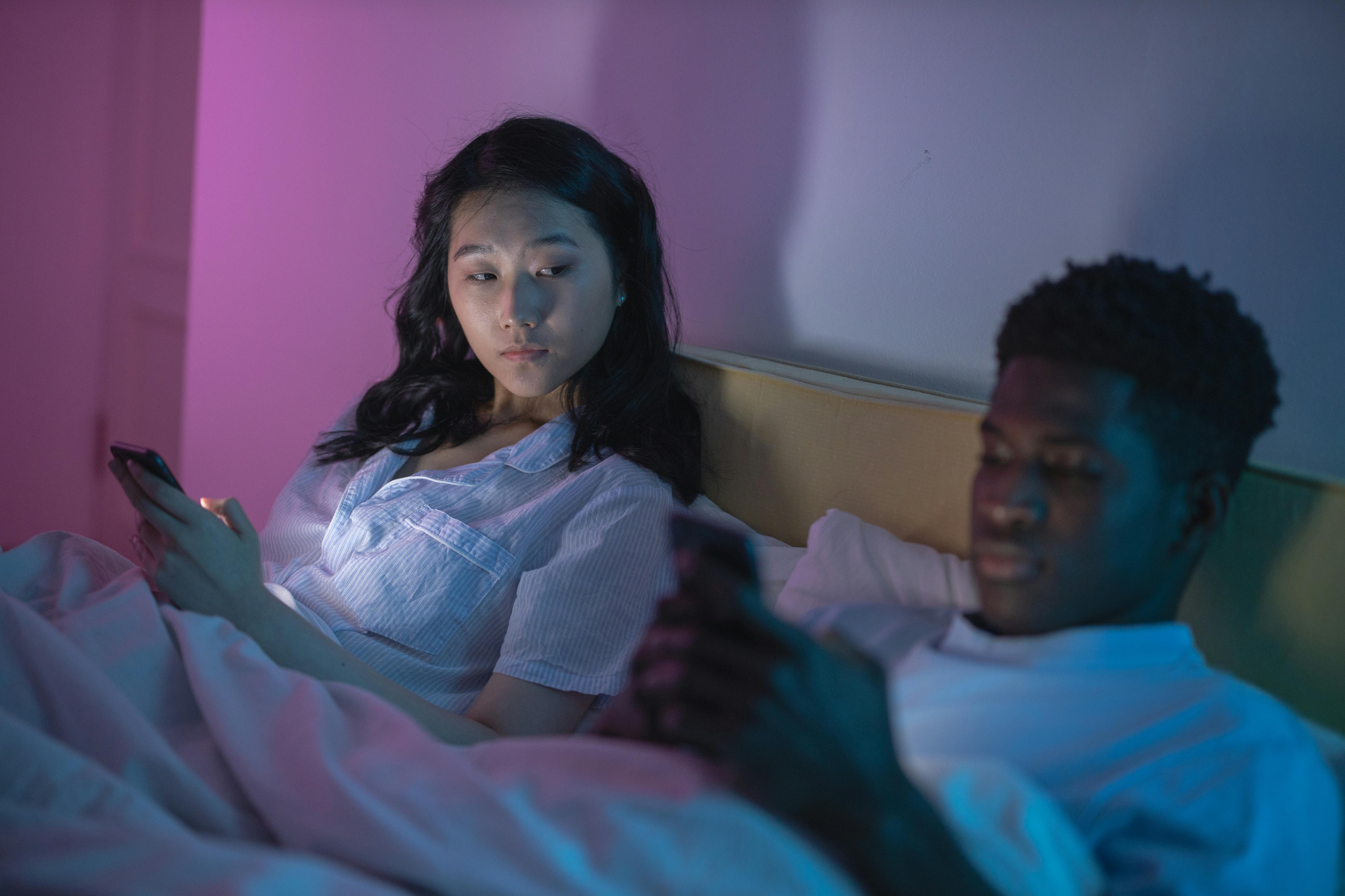 A woman looking at a man using his phone | Source: Pexels