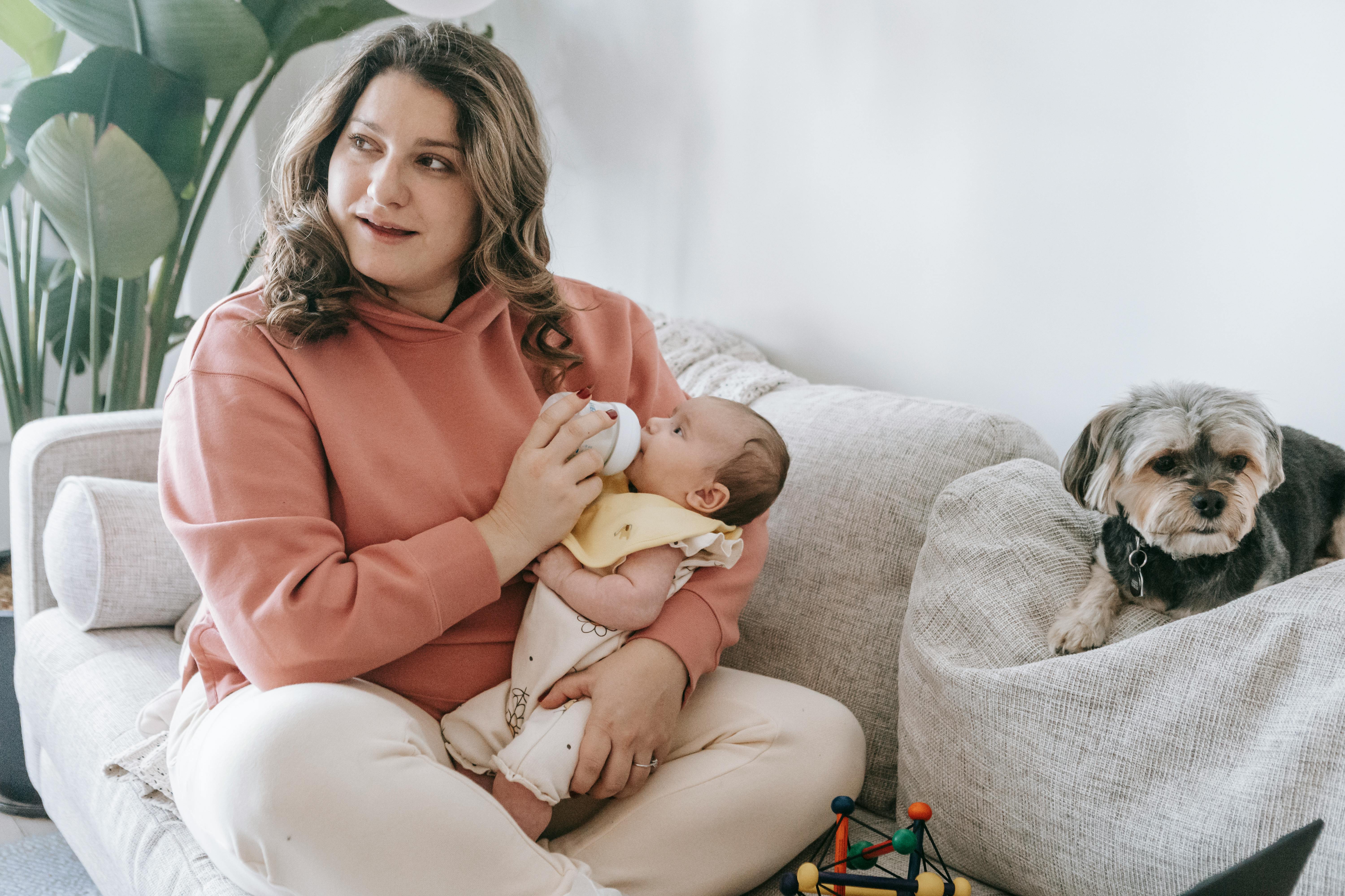 A woman bottle-feeding a child | Source: Pexels
