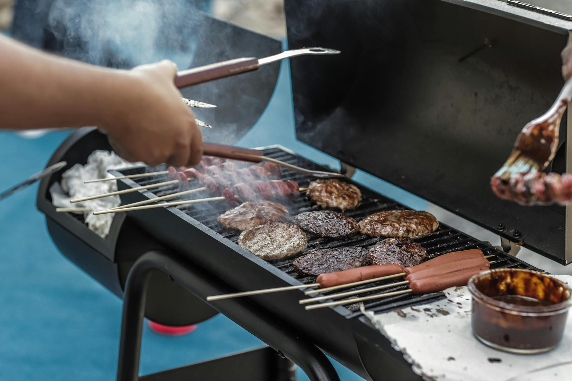 A person grilling sausages and meat | Source: Pexels